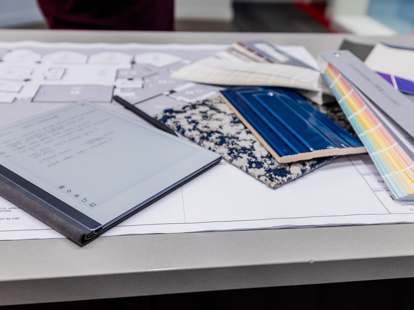 Interior design planning table with floor plans, material samples, and color swatches, illustrating the thoughtful decision-making process behind a strategic home renovation.