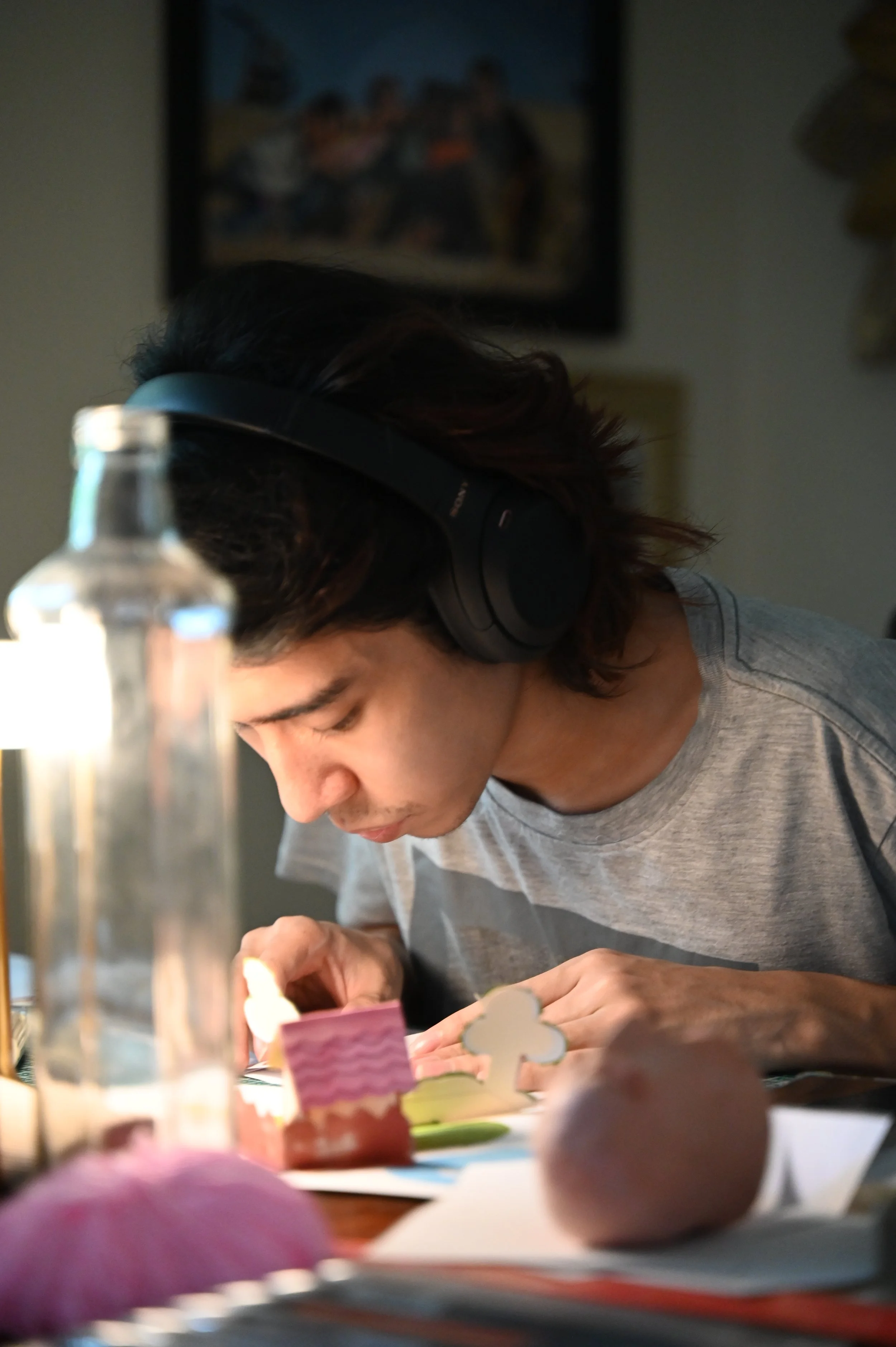 A man is concentrating while he crafts a pop up card.
