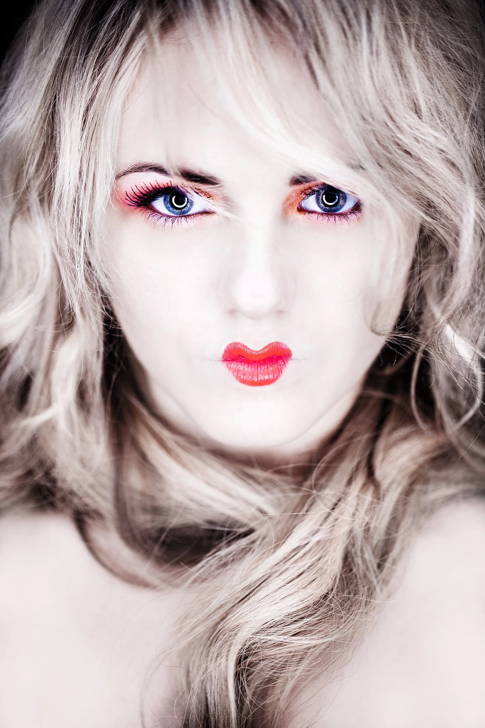 fashion photograph of close-up portrait of female model with blonde hair, vibrant red lipstick, and colorful eye makeup. Photography by Dave Wall Photo