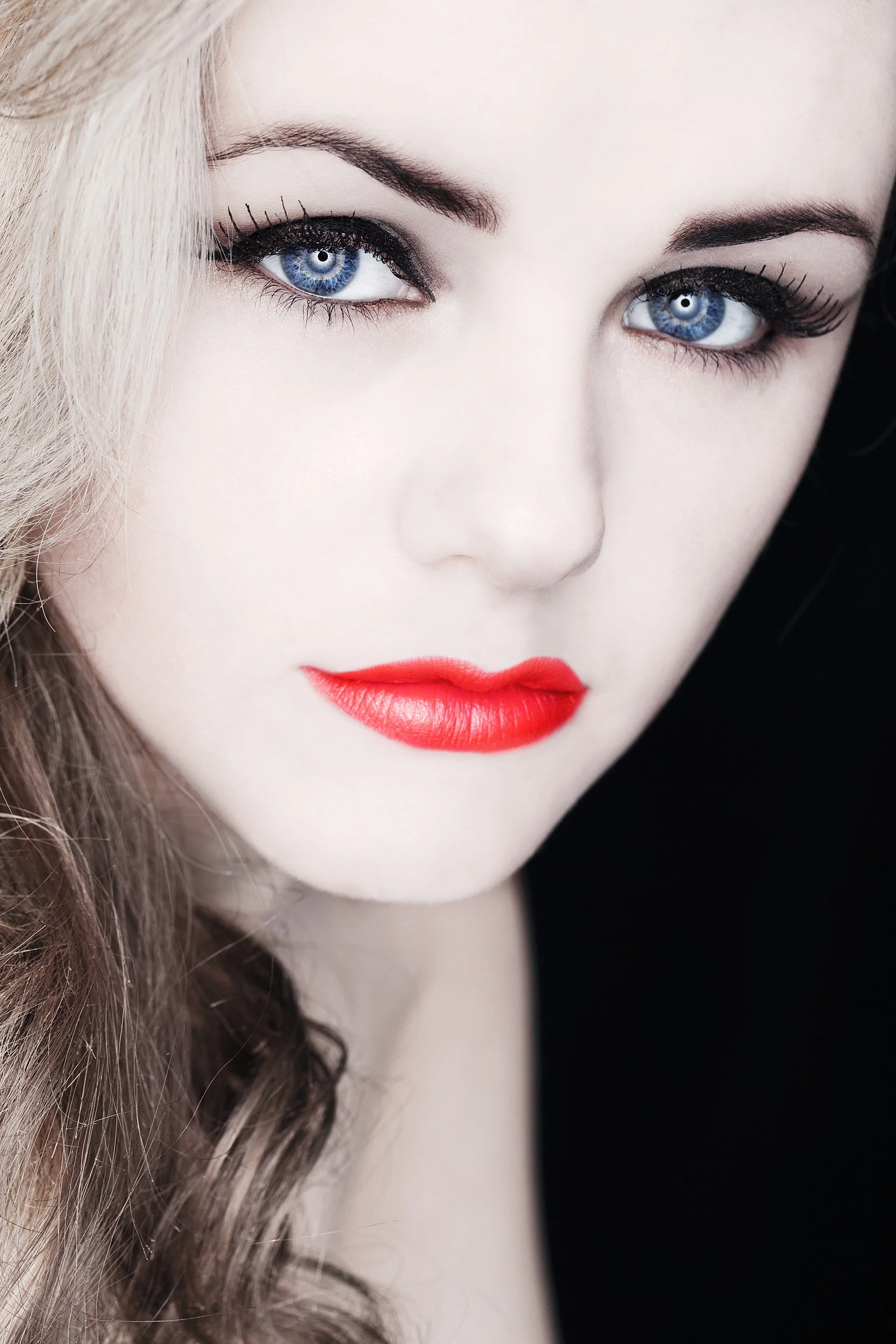 Fashion Photograph of close-up of a woman's face with blue eyes, red lipstick, and wavy blonde hair. Photography by Dave Wall Photo