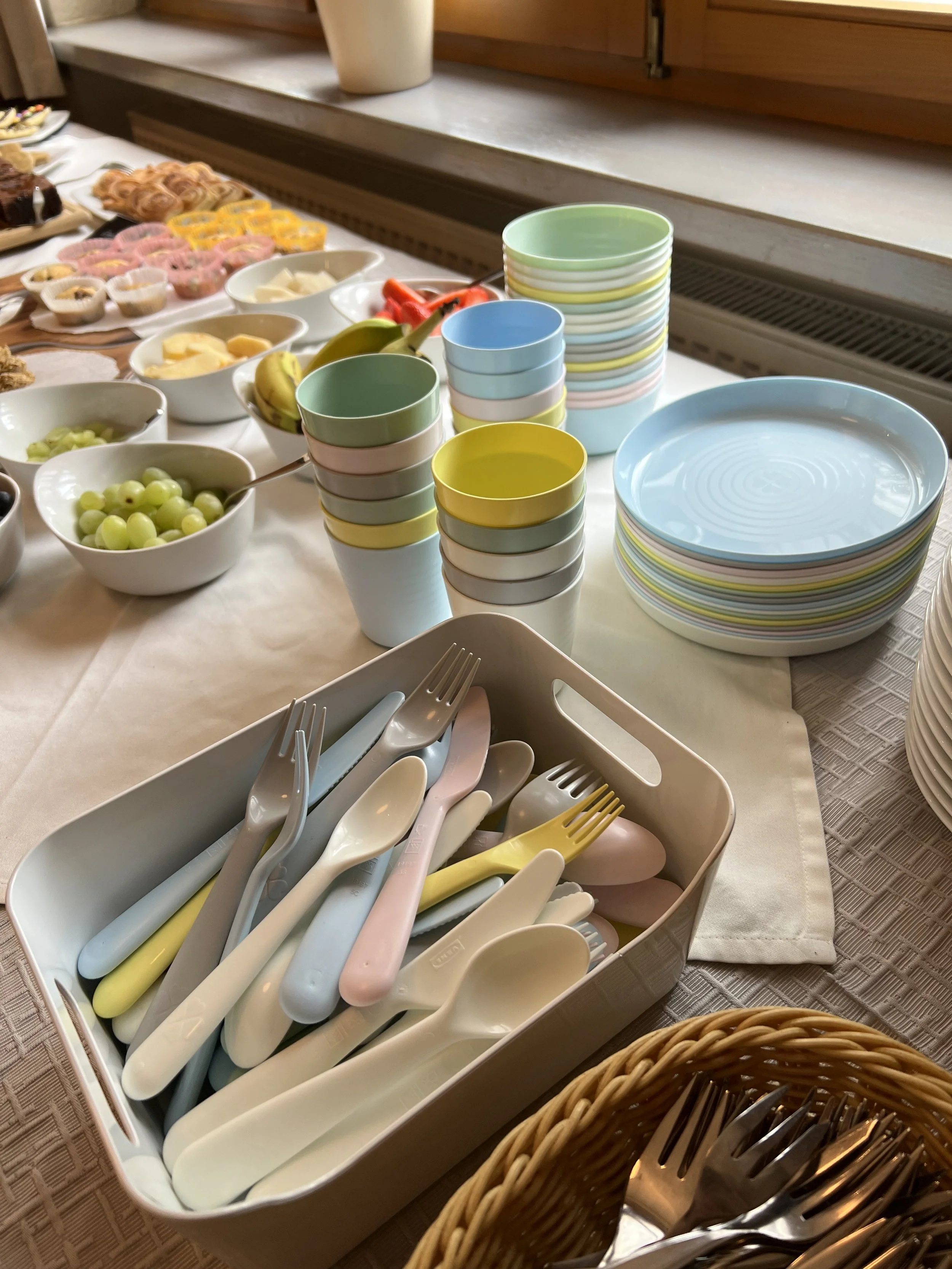 Teller mit bunten Schüsseln und Besteck, evt. für ein Frühstücksbuffet.