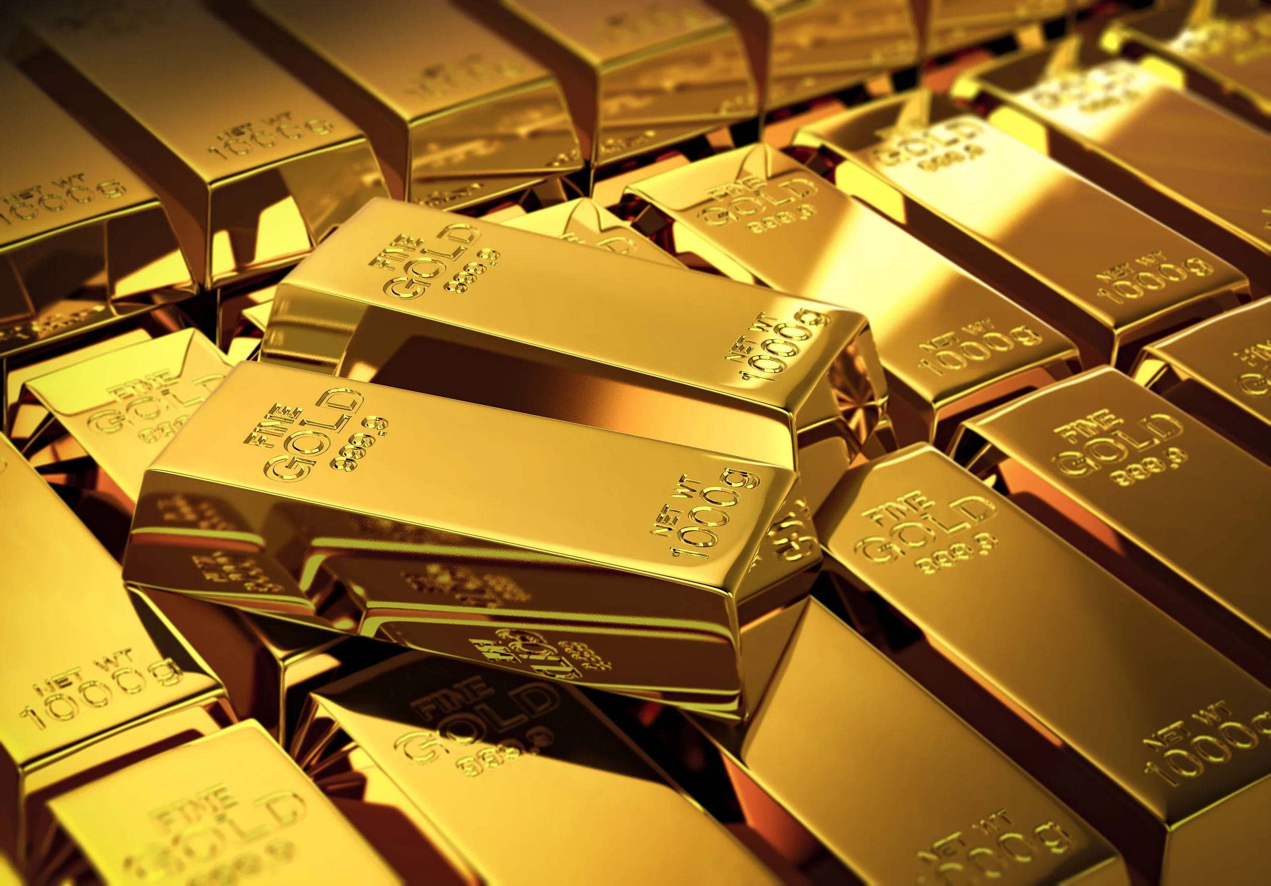 Multiple shiny gold bars stacked together, engraved with 'FINE GOLD 999.9 1000g'.