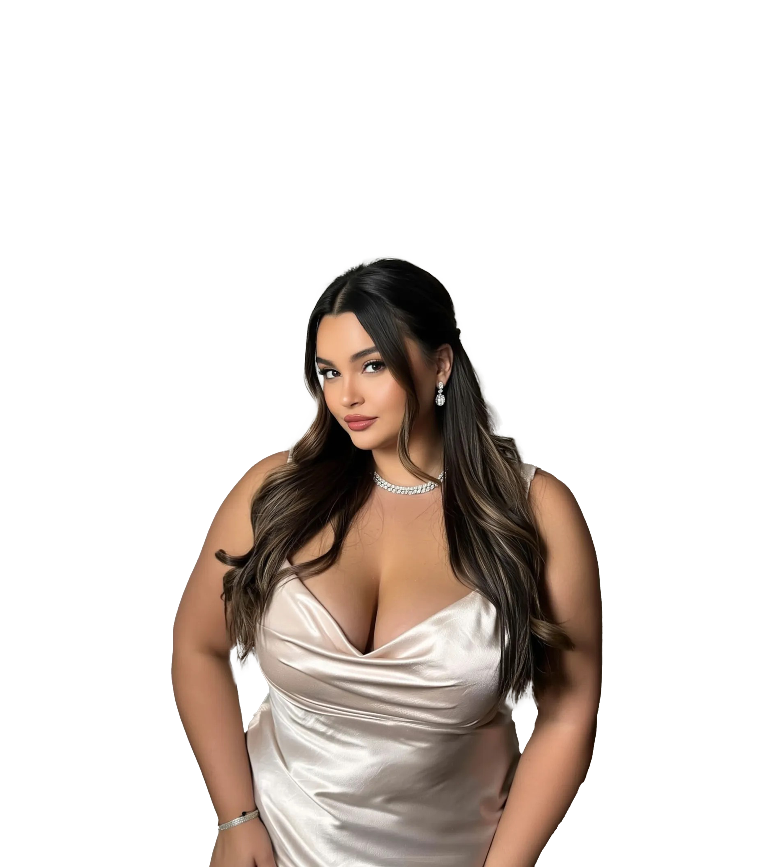 A woman with long dark hair in loose waves wearing a shiny, satin, cream-colored dress with a plunging neckline, accessorized with diamond jewelry, posing confidently.