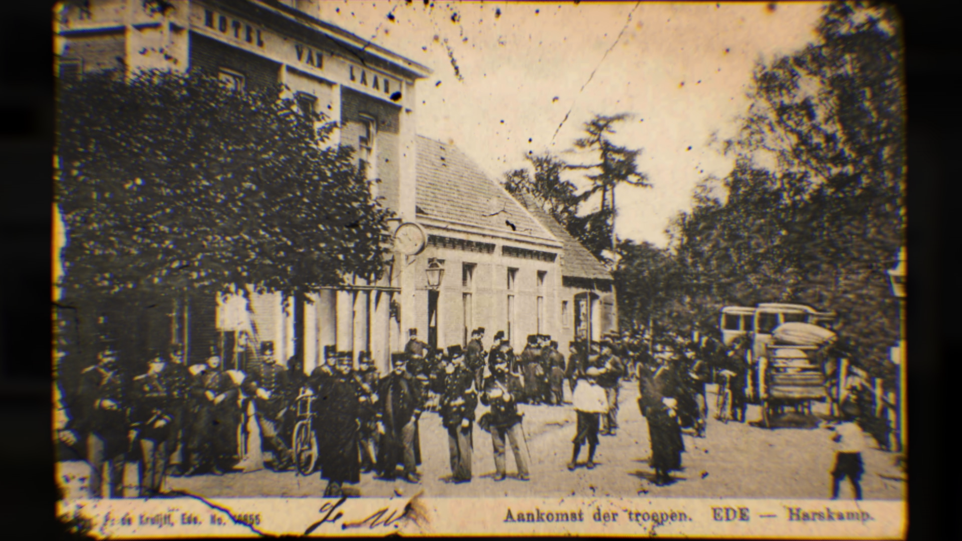 Zwart-wit oude foto van een groep soldaten en mensen in een straat met bomen en gebouwen, inclusief een paard en wagen.