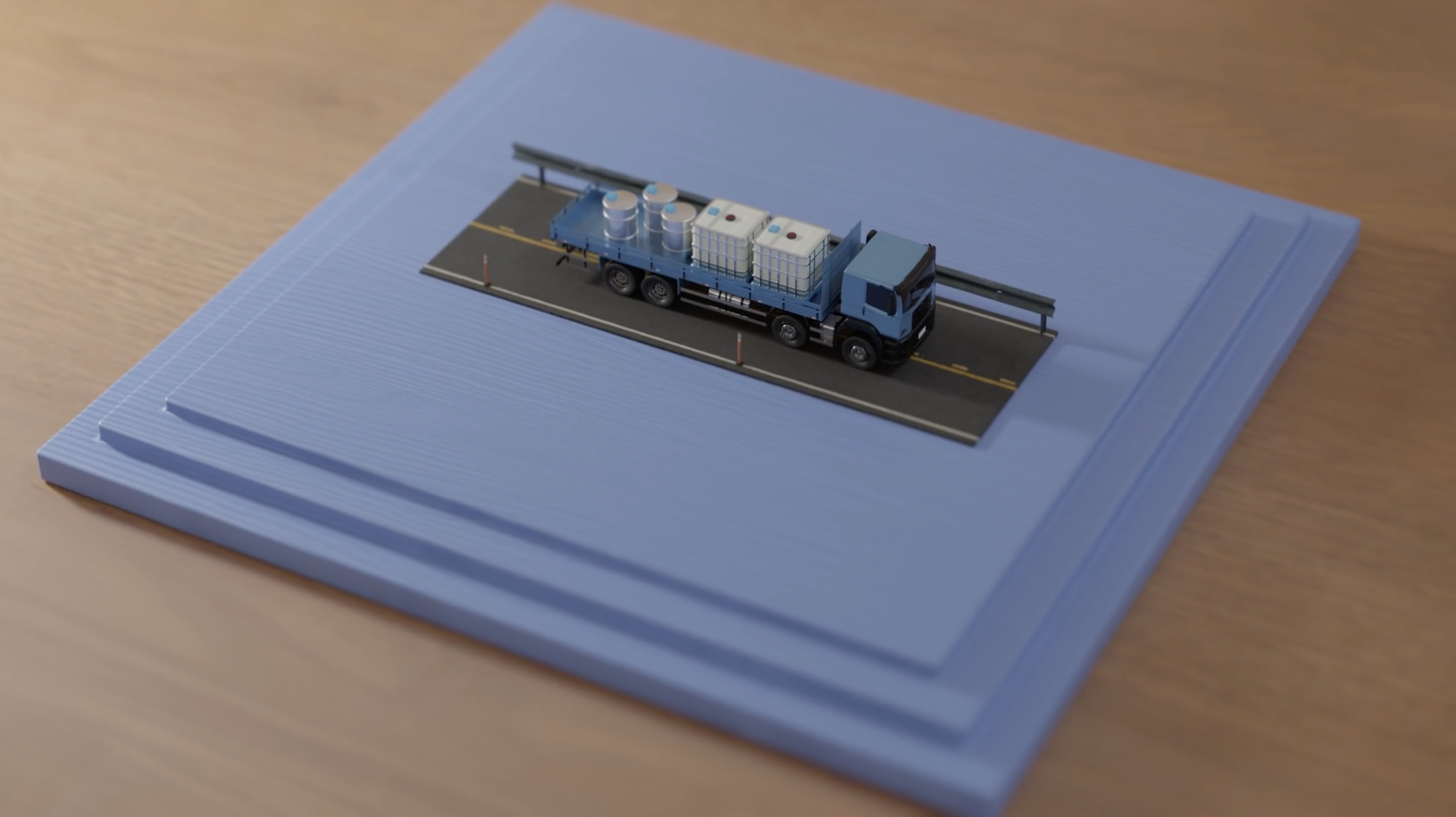 Miniatuurmodel van een vrachtwagen op een weg, geplaatst op een lichtblauwe basis op een houten tafel.