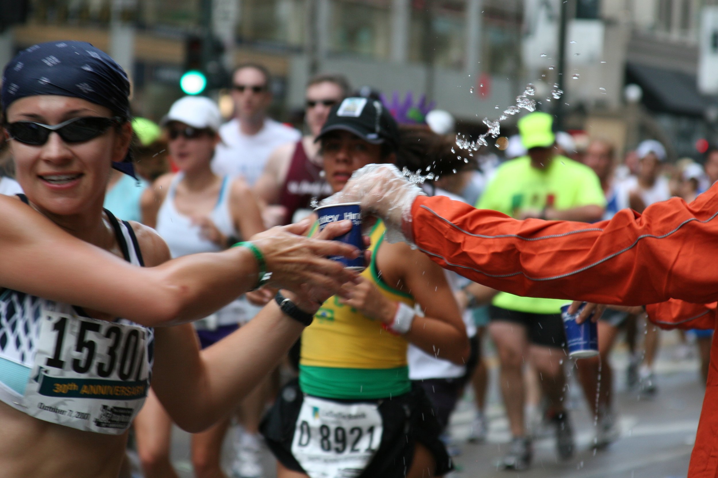 Marathon runners passing out water to each other during a race.