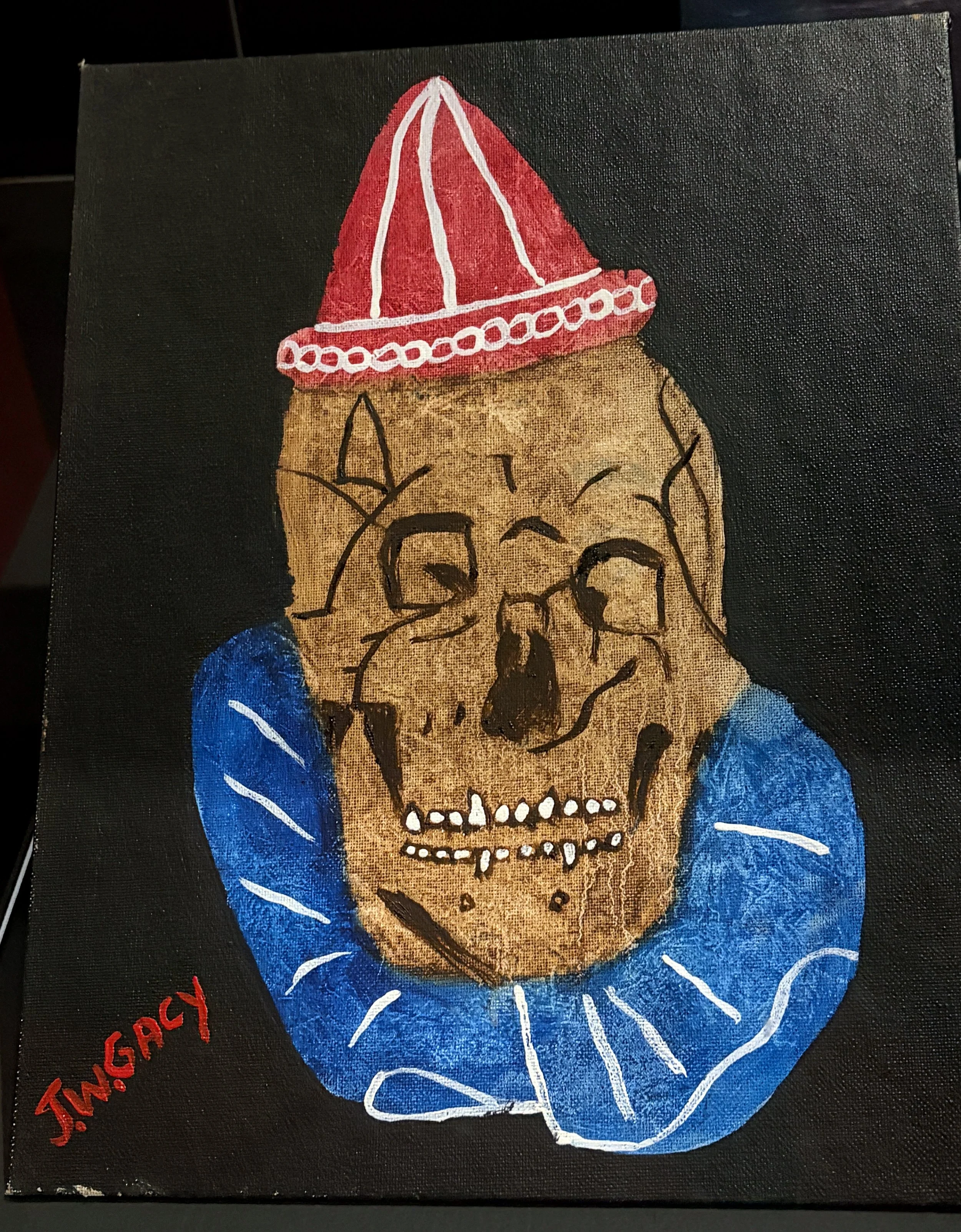 A painting of a human skull with a red and white party hat, blue clothing, and decorative white lines on the clothing, against a black background.