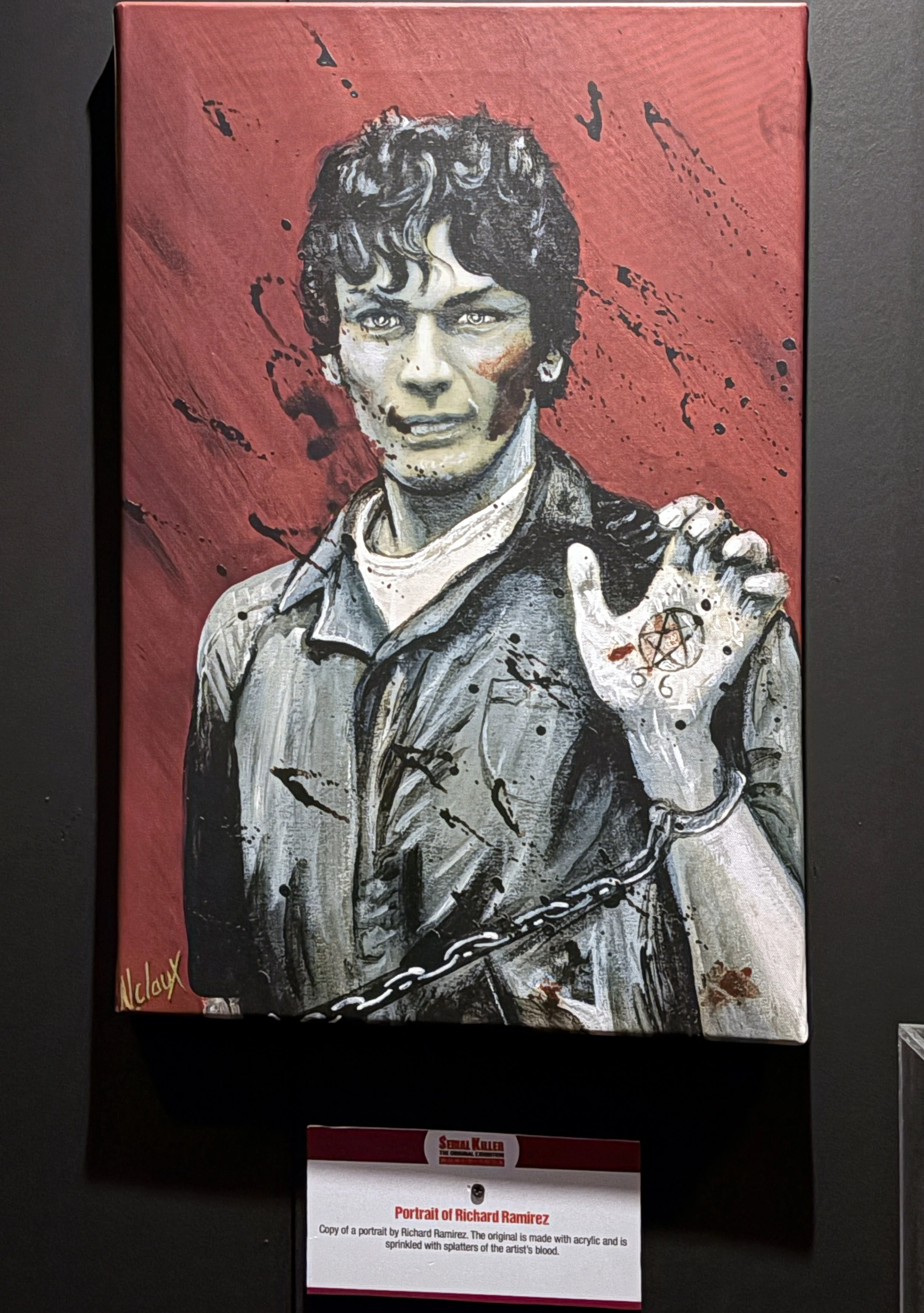 Painting titled 'Portrait of Richard Ramirez' by Richard Ramirez. It depicts a man with dark curly hair, wearing a sheriff's badge on his shirt, holding a chain, with splatters of red and black representing blood in the background.