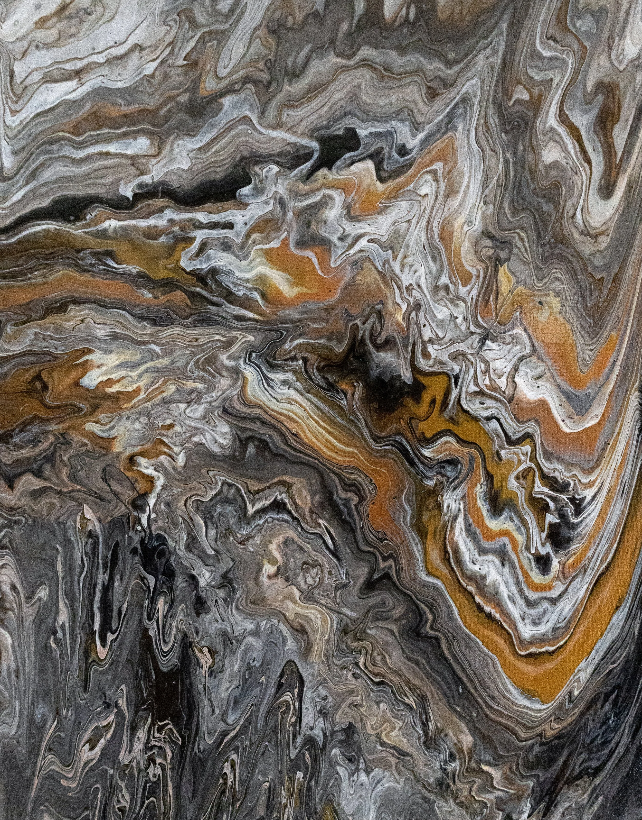 Abstract swirling pattern in shades of black, gray, white, and brown.