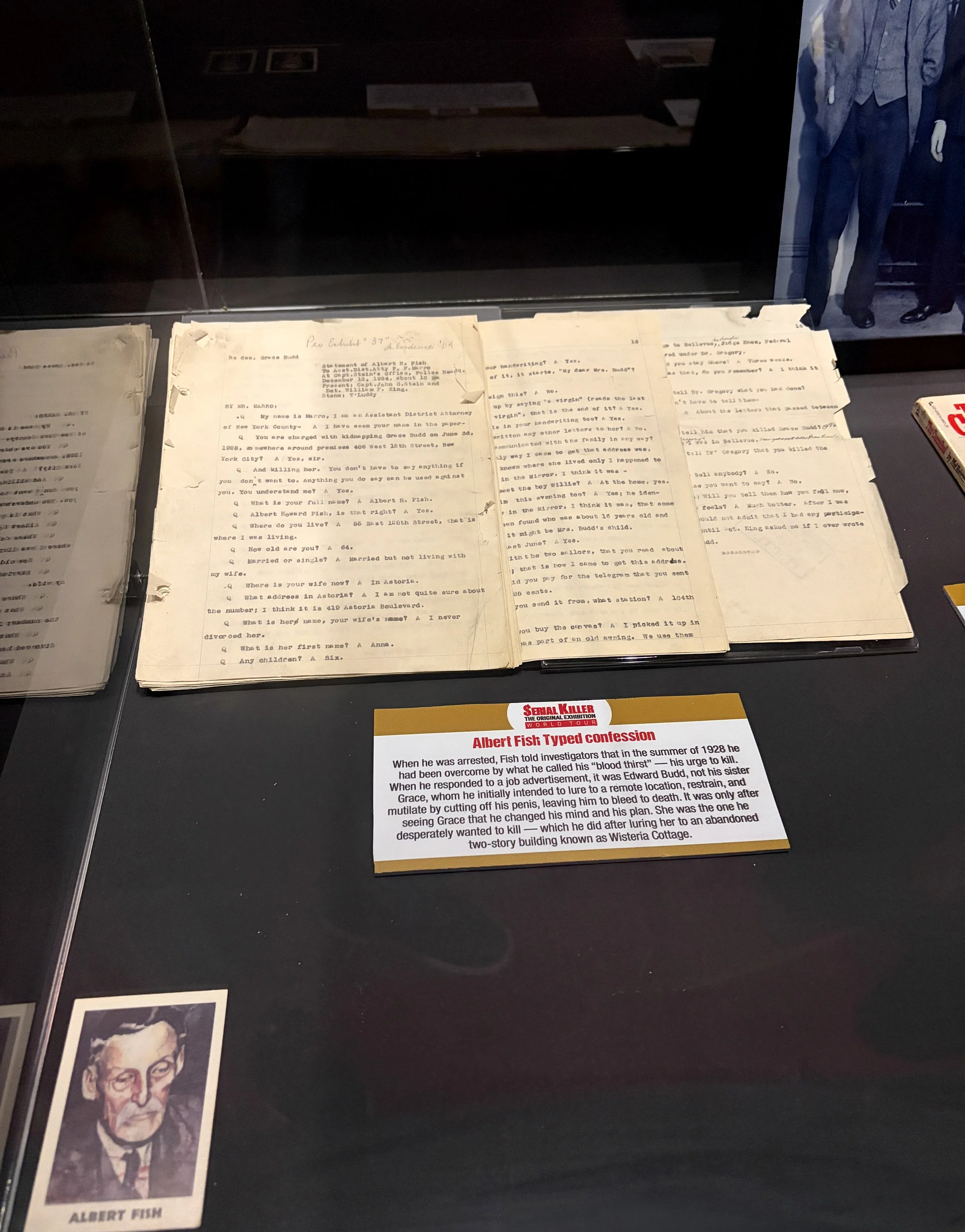 A display case containing documents and photographs related to Albert Fish, including typed confessions and a portrait illustration, with informational text about his crimes.