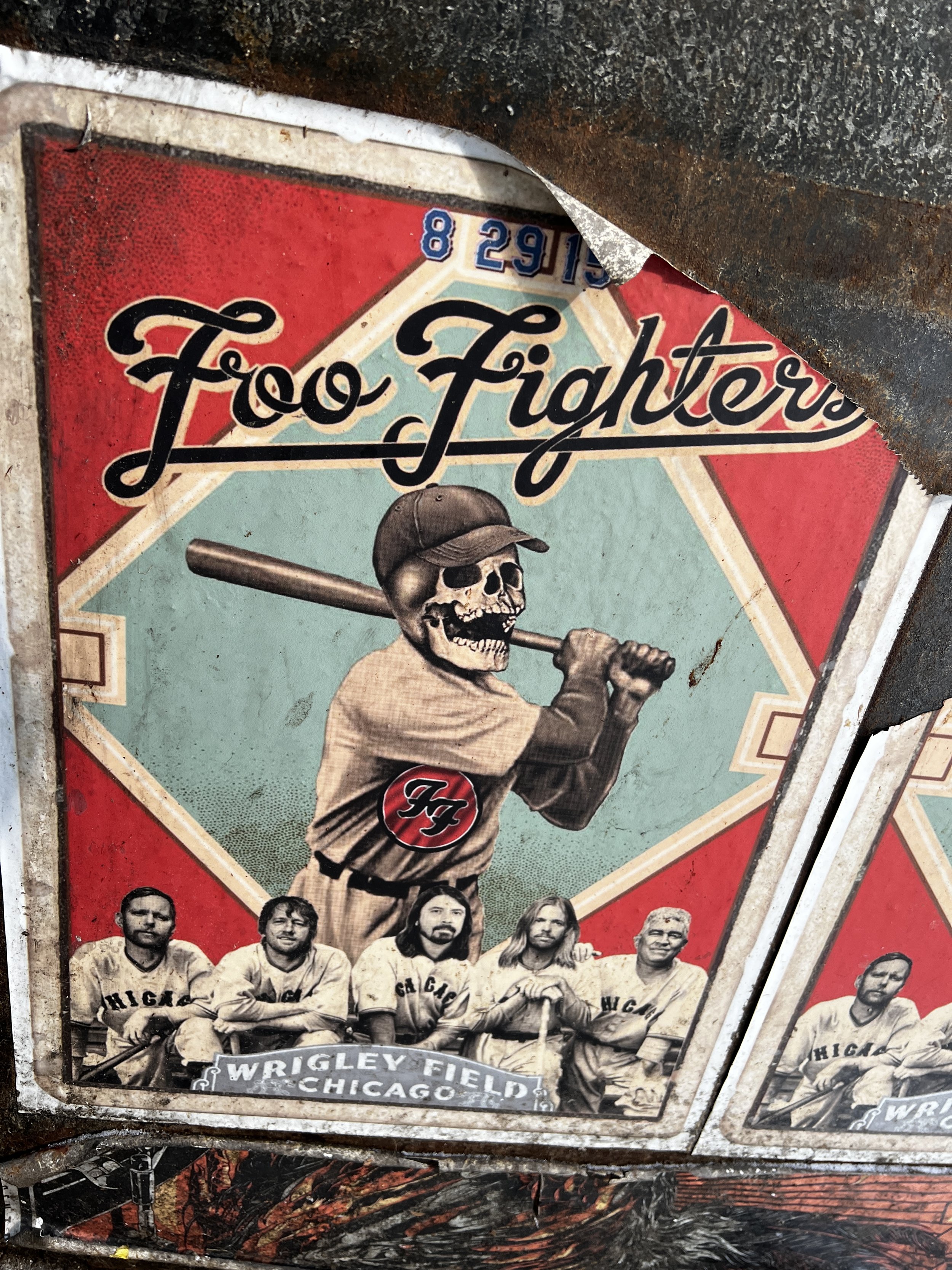 Vintage metal sign featuring a black and white photo of the 1910 Chicago White Sox baseball team, with a large skeleton baseball player holding a bat above his shoulder, wearing a cap. The sign includes the text "Wrigley Field Chicago" and "HIG" on t