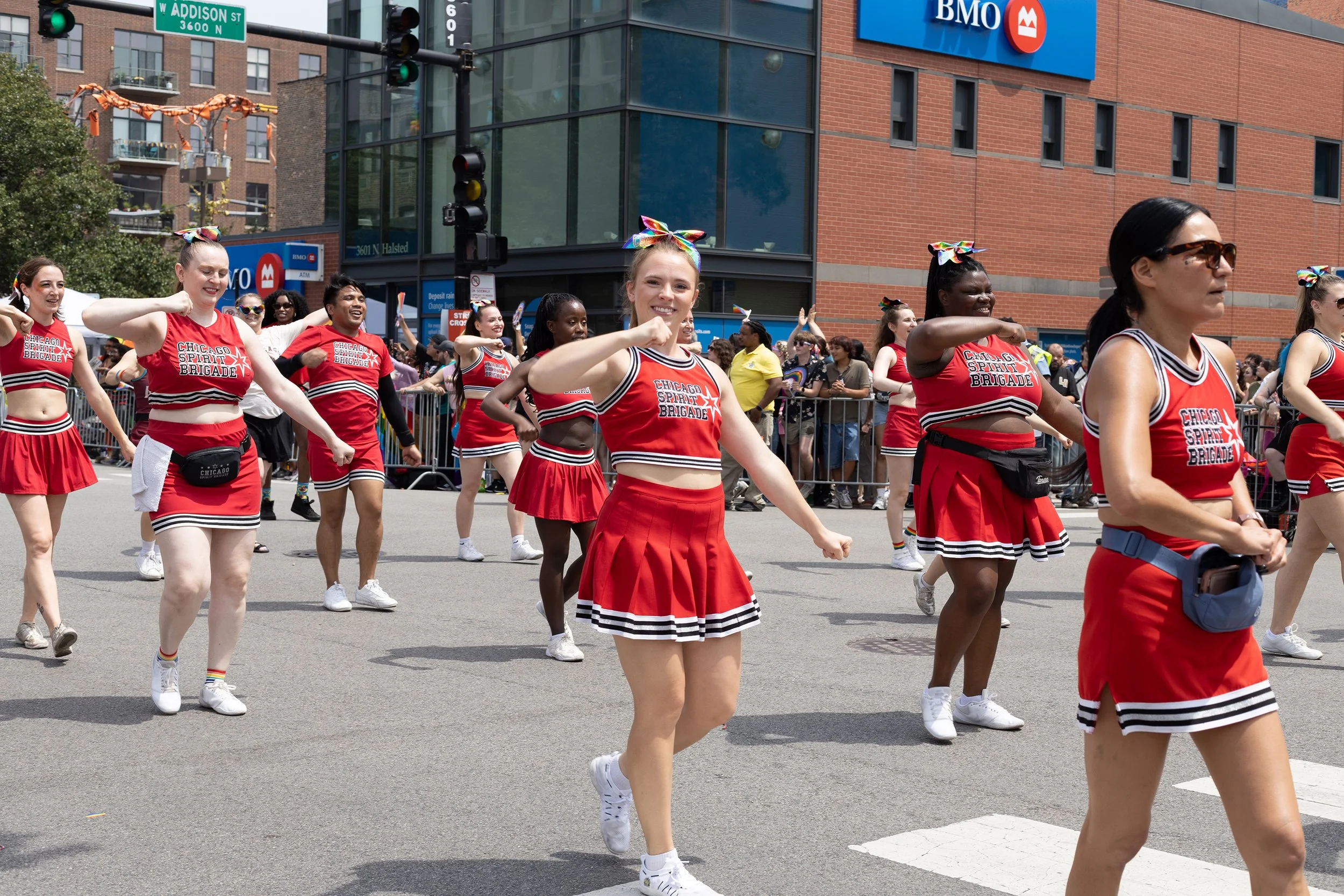 A group of women dressed as cheerleaders in red, black, and white outfits with 