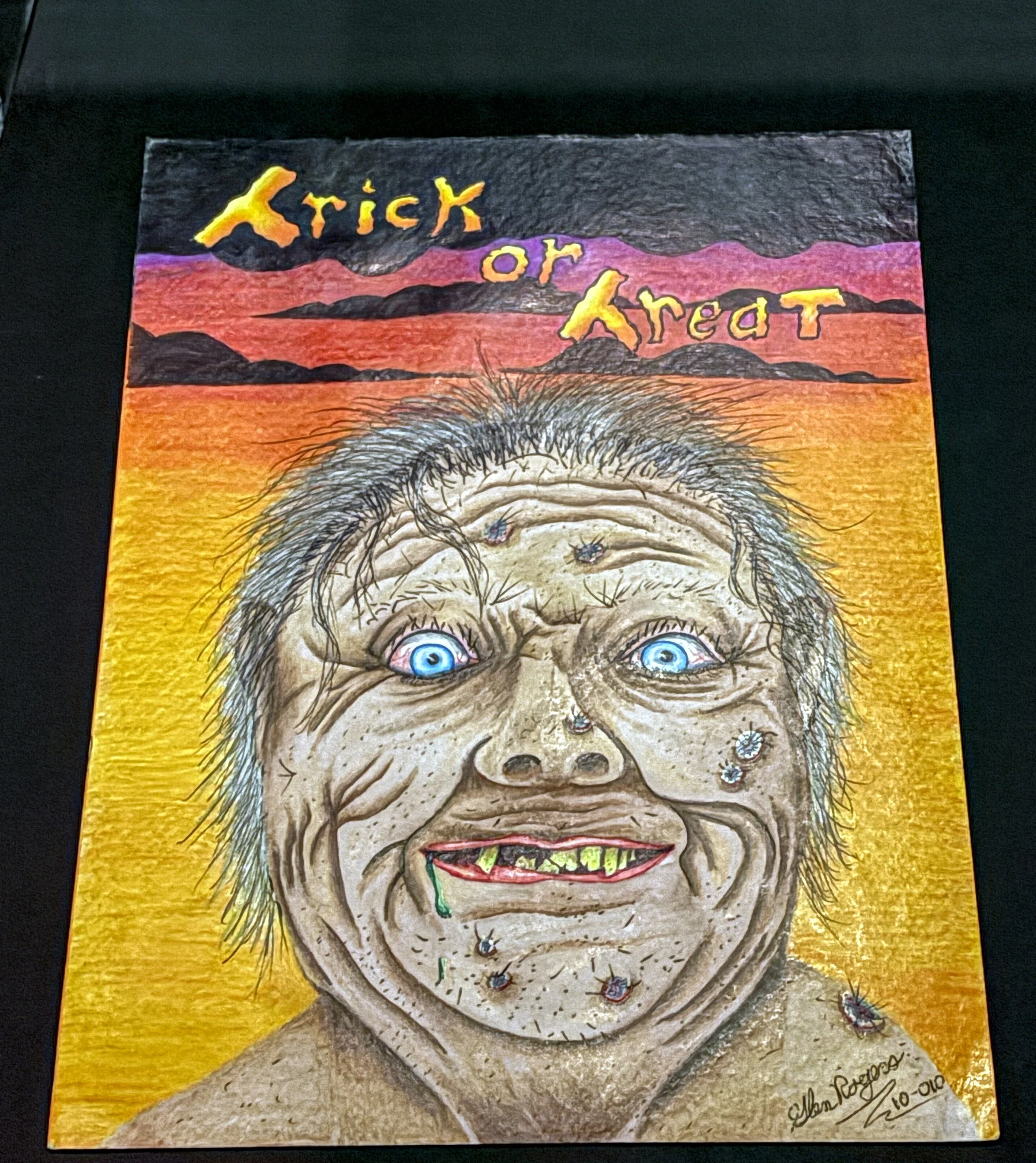A colorful drawing of a portrait of a skeleton with wild hair, wide-open blue eyes, and a big toothy grin, set against a background of mountains and a vibrant sunset, with the words 'Trick or Treat' written at the top.