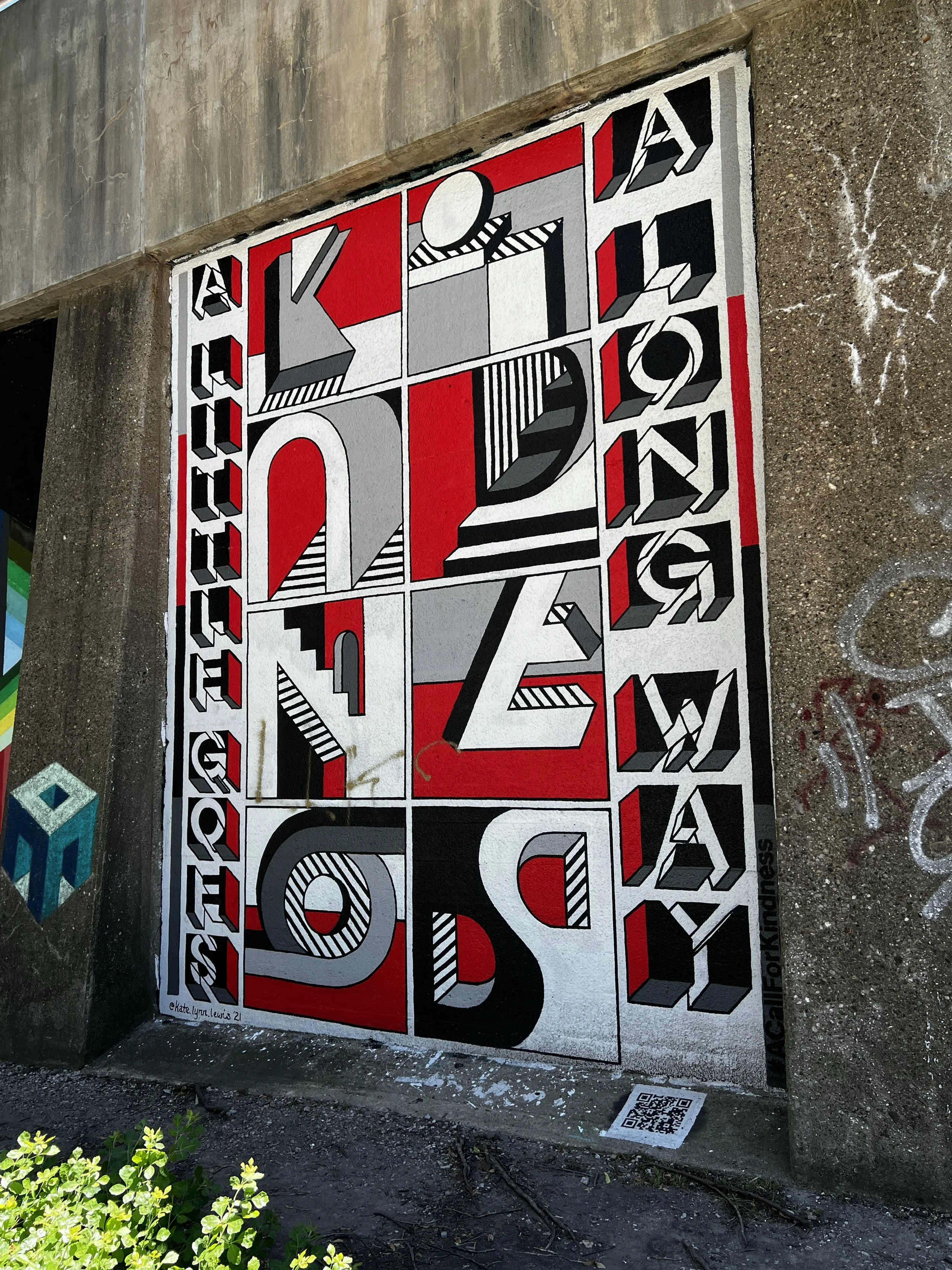 Colorful street art on a concrete wall featuring geometric shapes, bold lines, and the word 'HOPE' in stylized letters with red, black, white, and gray colors.