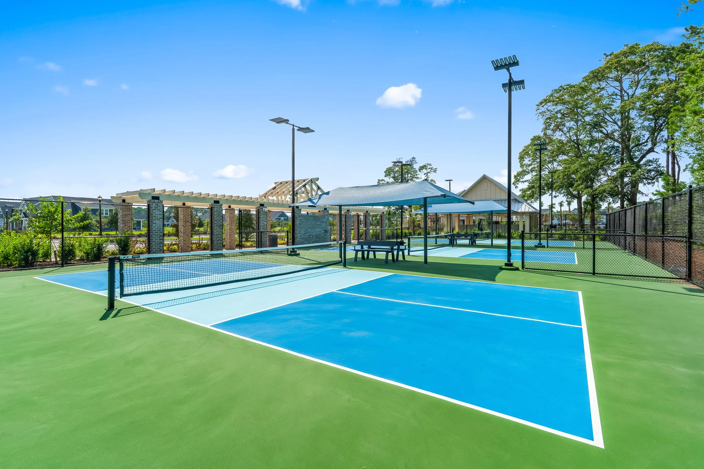 Pickleball courts with covered seating areas at Grand Dunes North Amenity Center