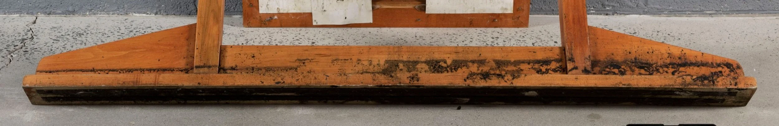 Close up of a layer of black soot that accumulated on a wooden vanity while stored in a room next to another room that caught on fire