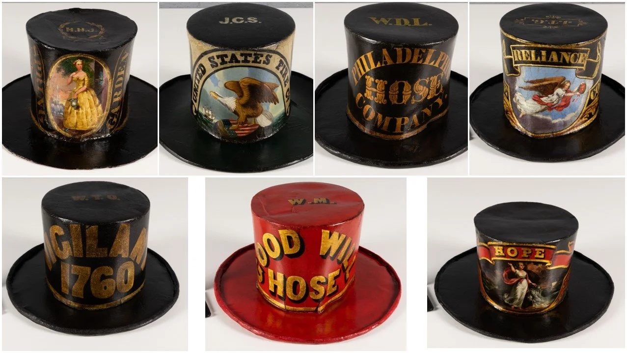 Series of seven fireman parade hats after treatment. Hats look like top hats. Six are black and one is bright red. All have images, text, or both on them to denote which fire company they represent.