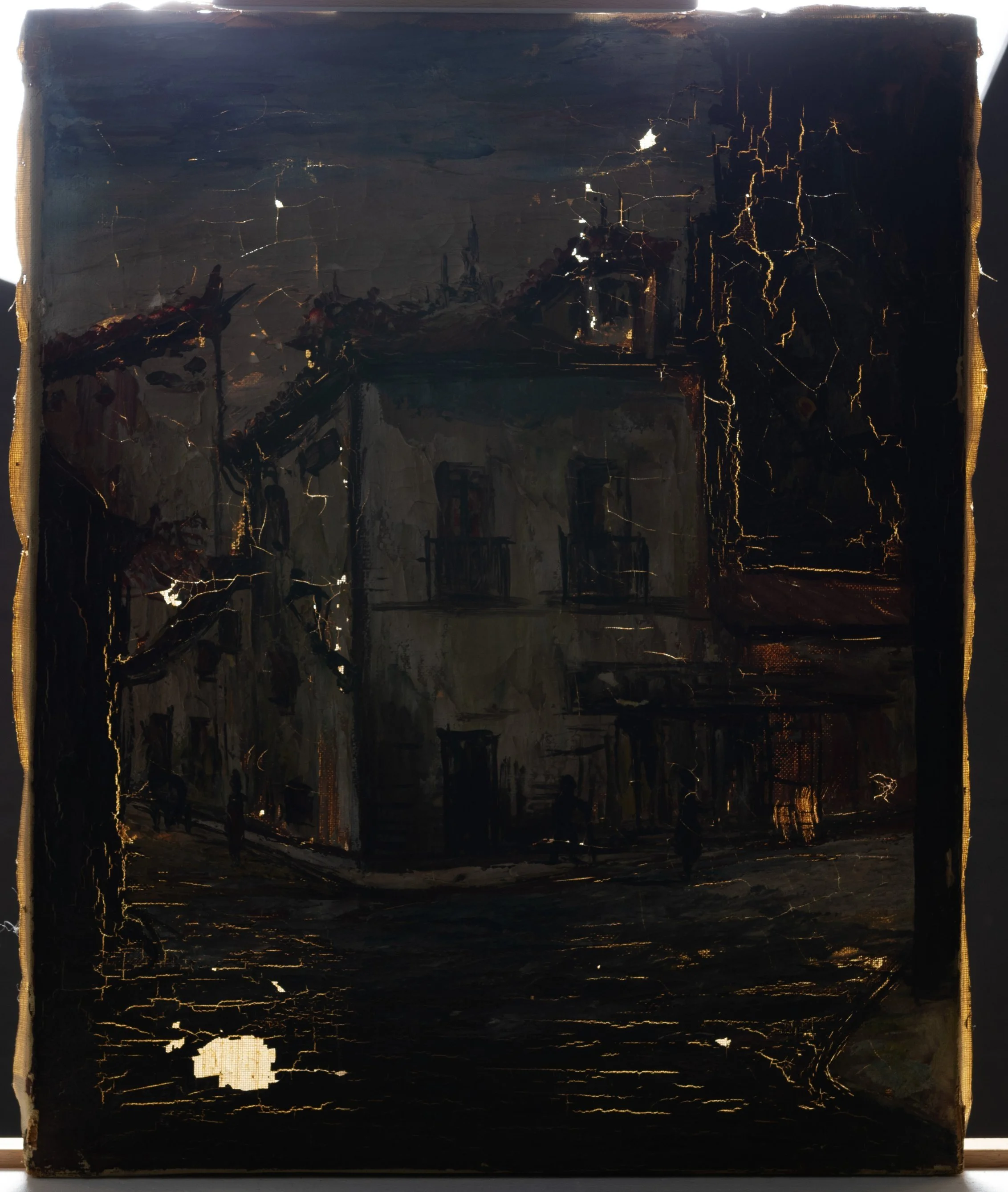 Painting of a house on a corner, on an easel, but the painting is very dark because it is under transmitted illumination. The lights behind the painting do show many areas of paint loss and cracks in the paint as bright, white spots on the canvas.