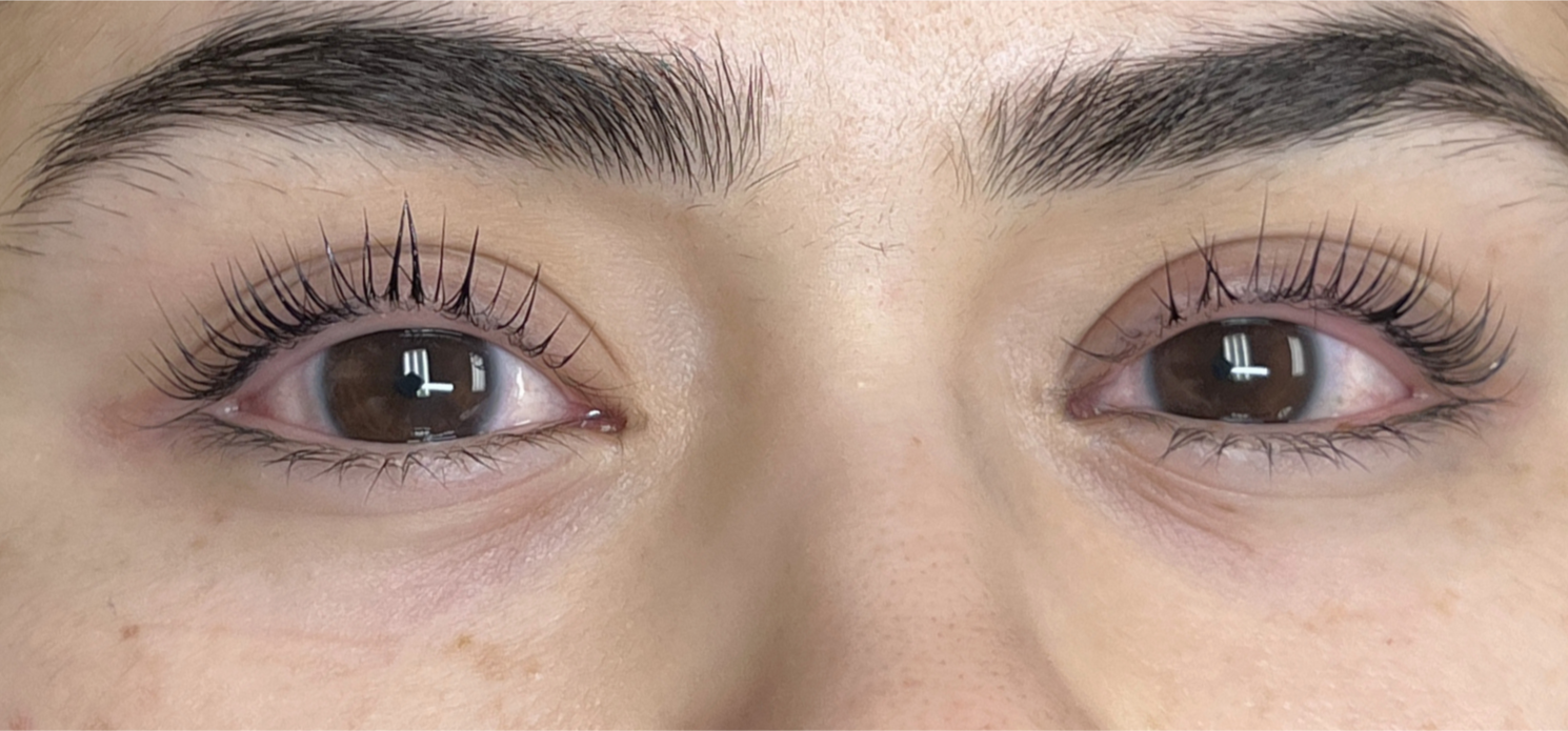 Close-up of a person's eyes with dark brown irises, lash lift and tint, and well-groomed eyebrows.