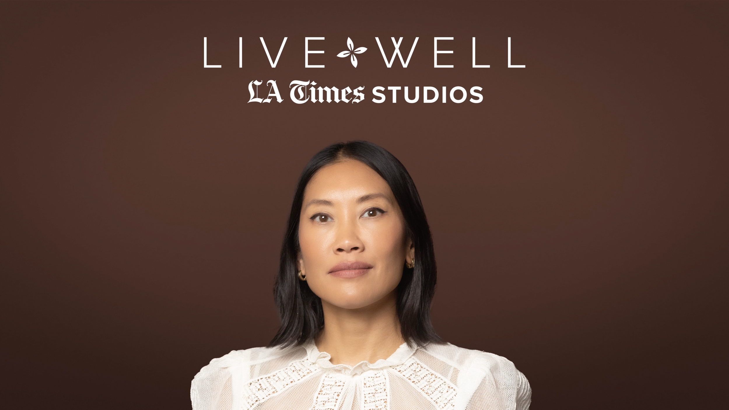 A woman with black hair and a white lace blouse smiling slightly, with the words 'LIVE WELL' and 'LA Times STUDIOS' above her head on a brown background.