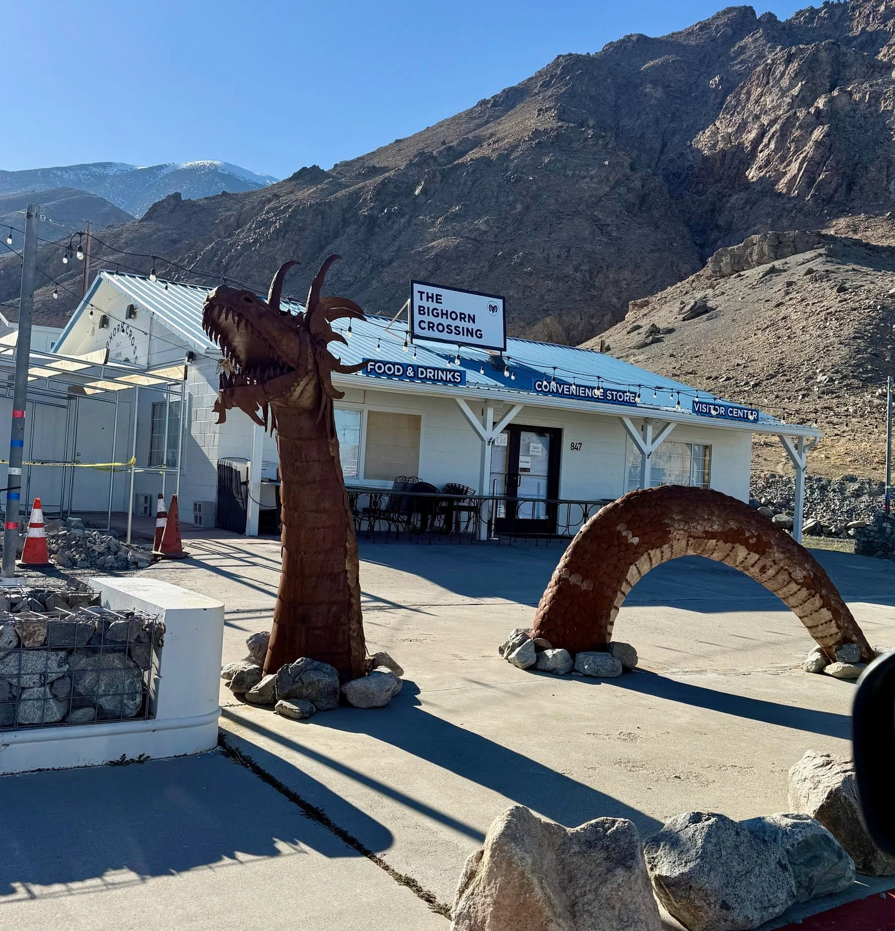 The Bighorn Crossing restaurant, convenience store and visitor center, with a dragon sculpture in front along mountain side