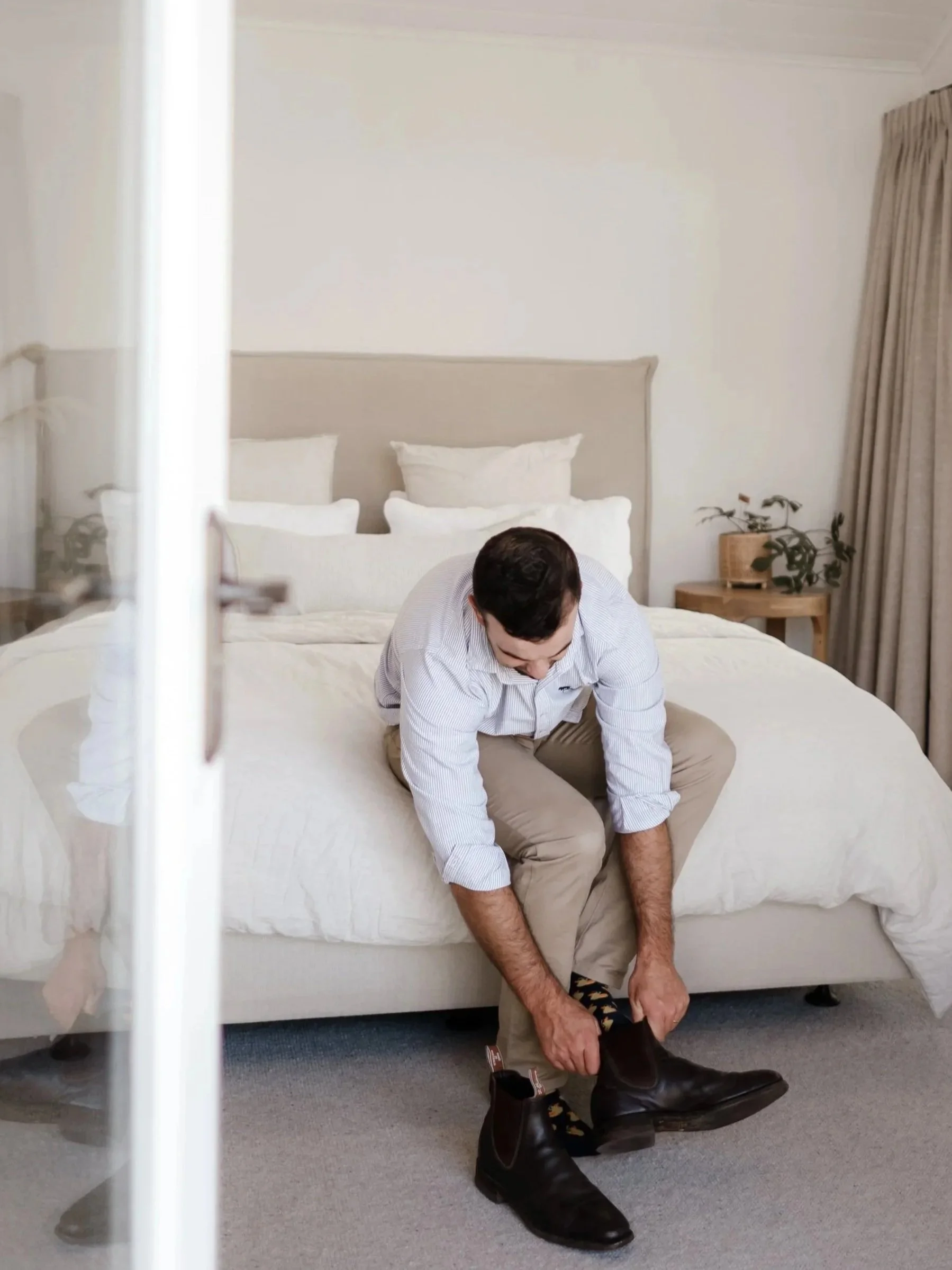 Home builder in bright, modern master bedroom with custom farmhouse details.