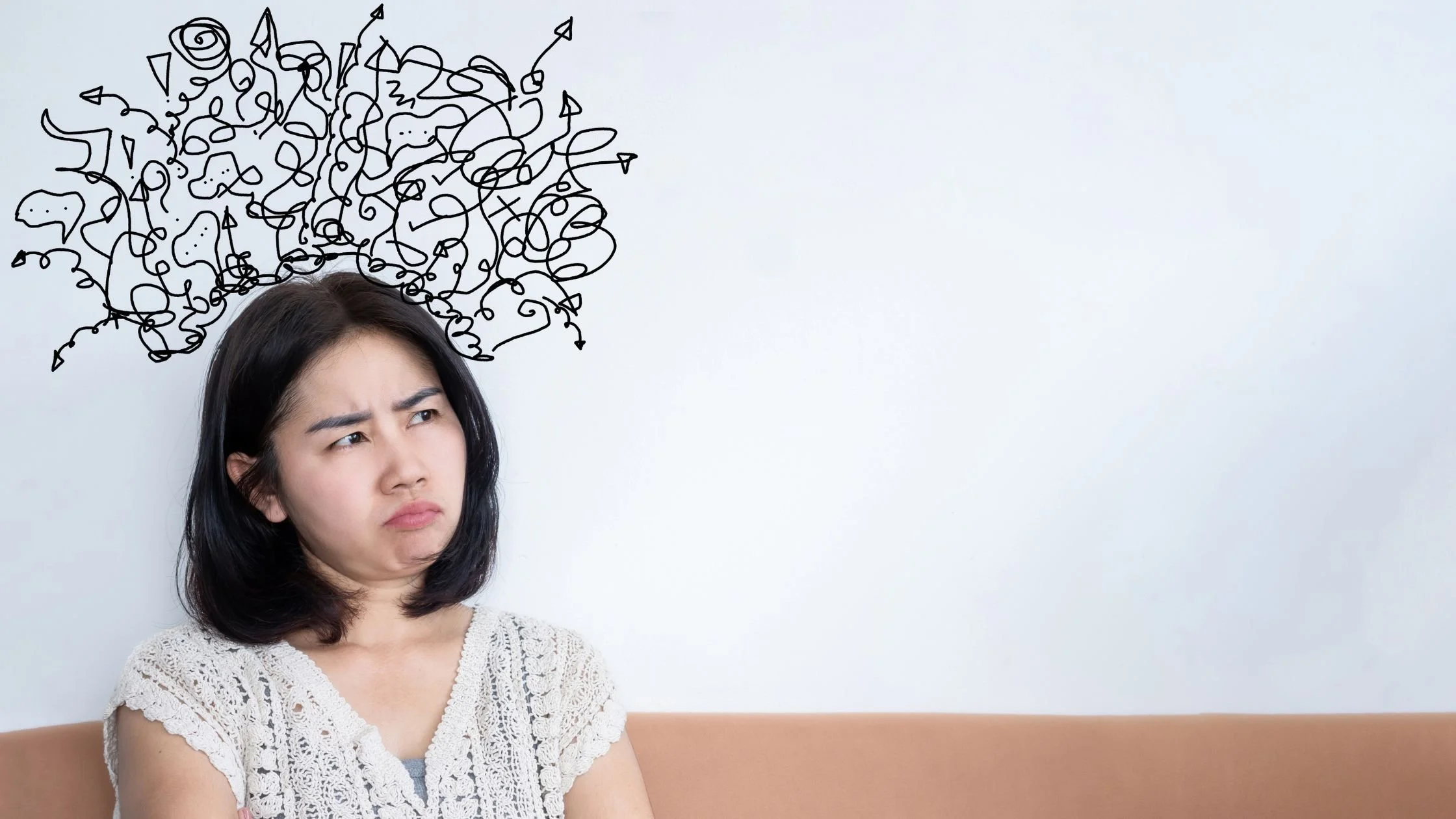 woman frowning with squiggles drawn above her head like a thought bubble