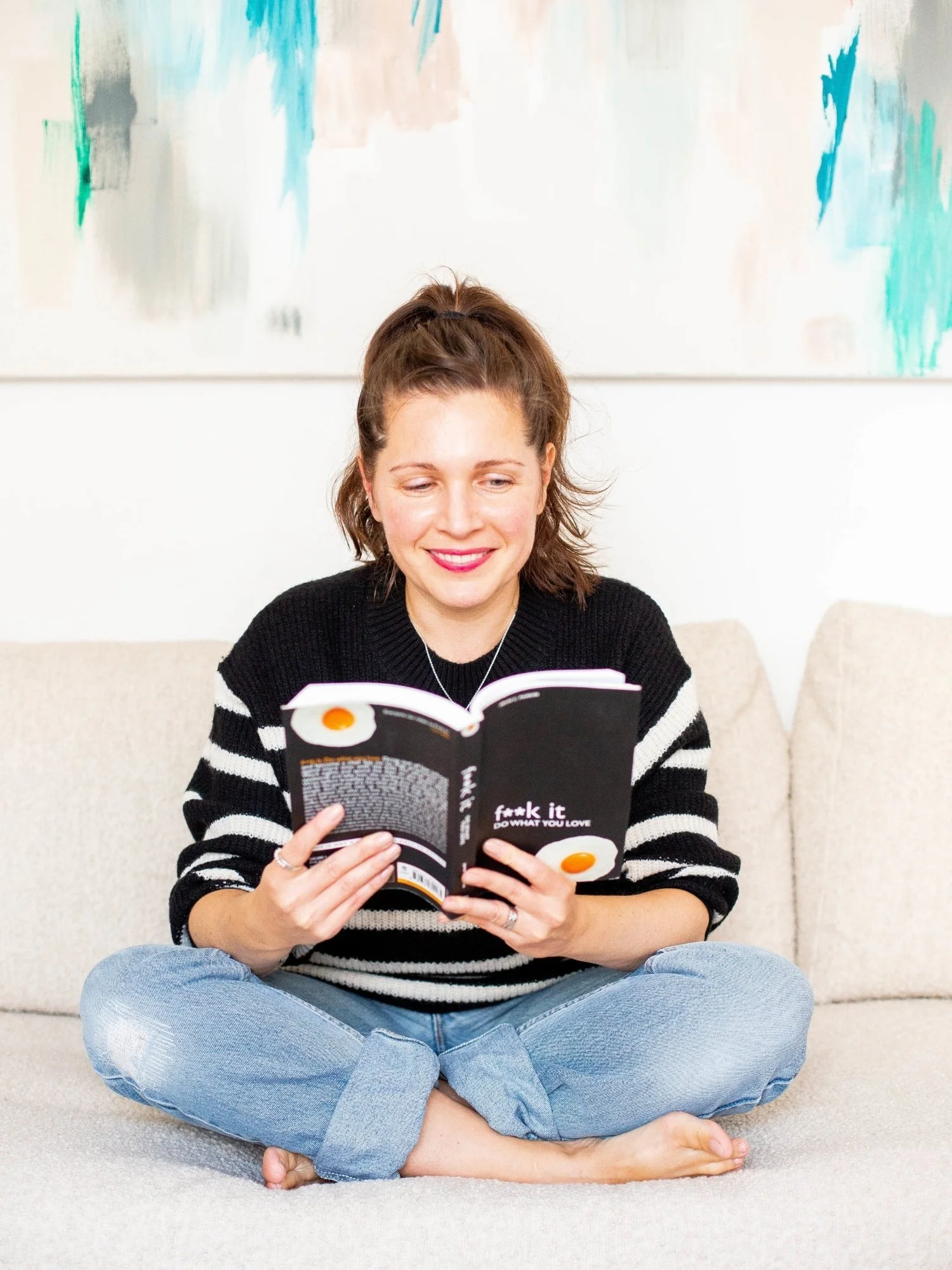 Sam Ferguson creator of Found & Followed course, holding book and reading, sitting cross legged