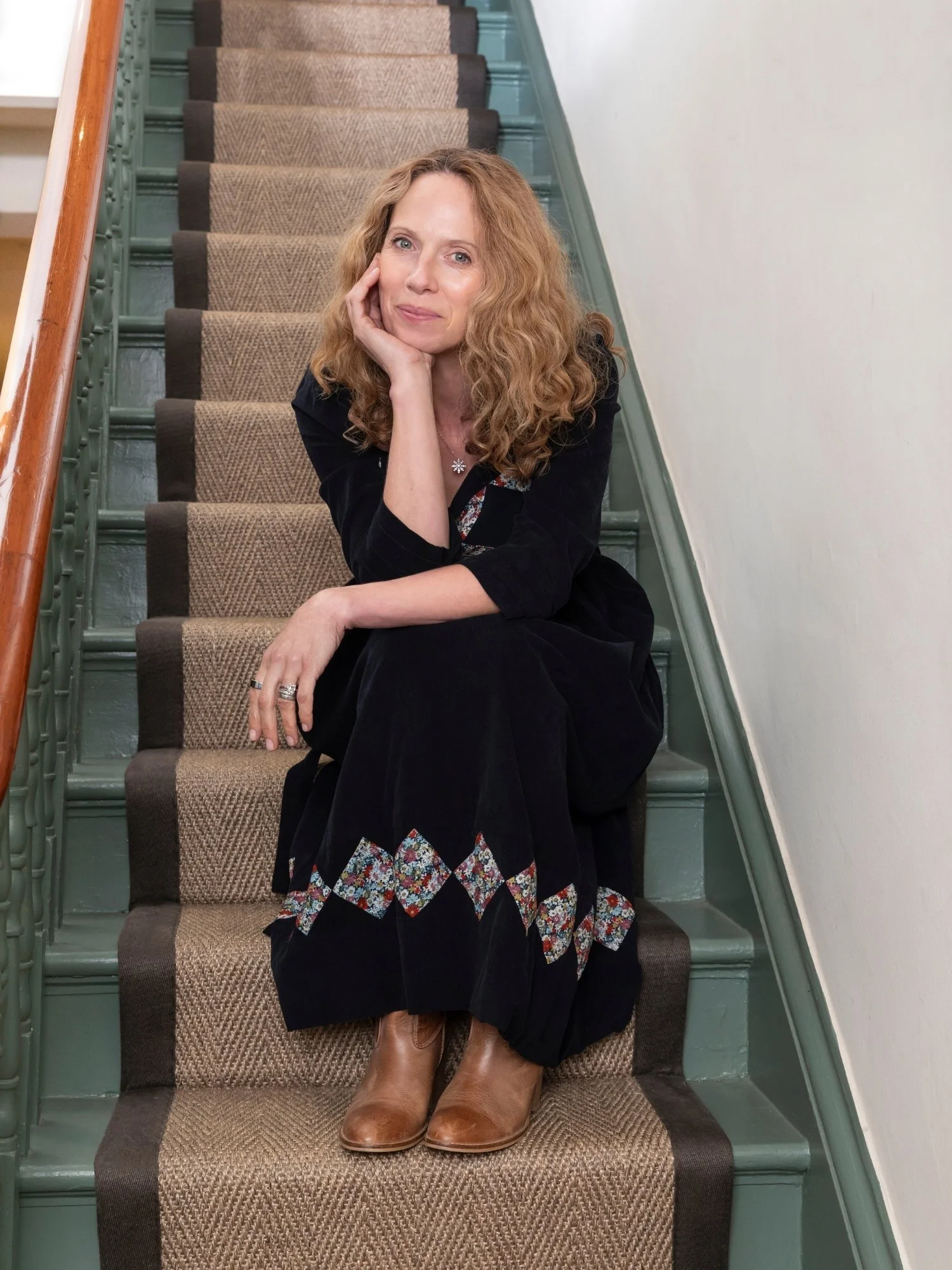 Alison Hall, Nutritional Therapist, sitting on stairs, head resting on her hand