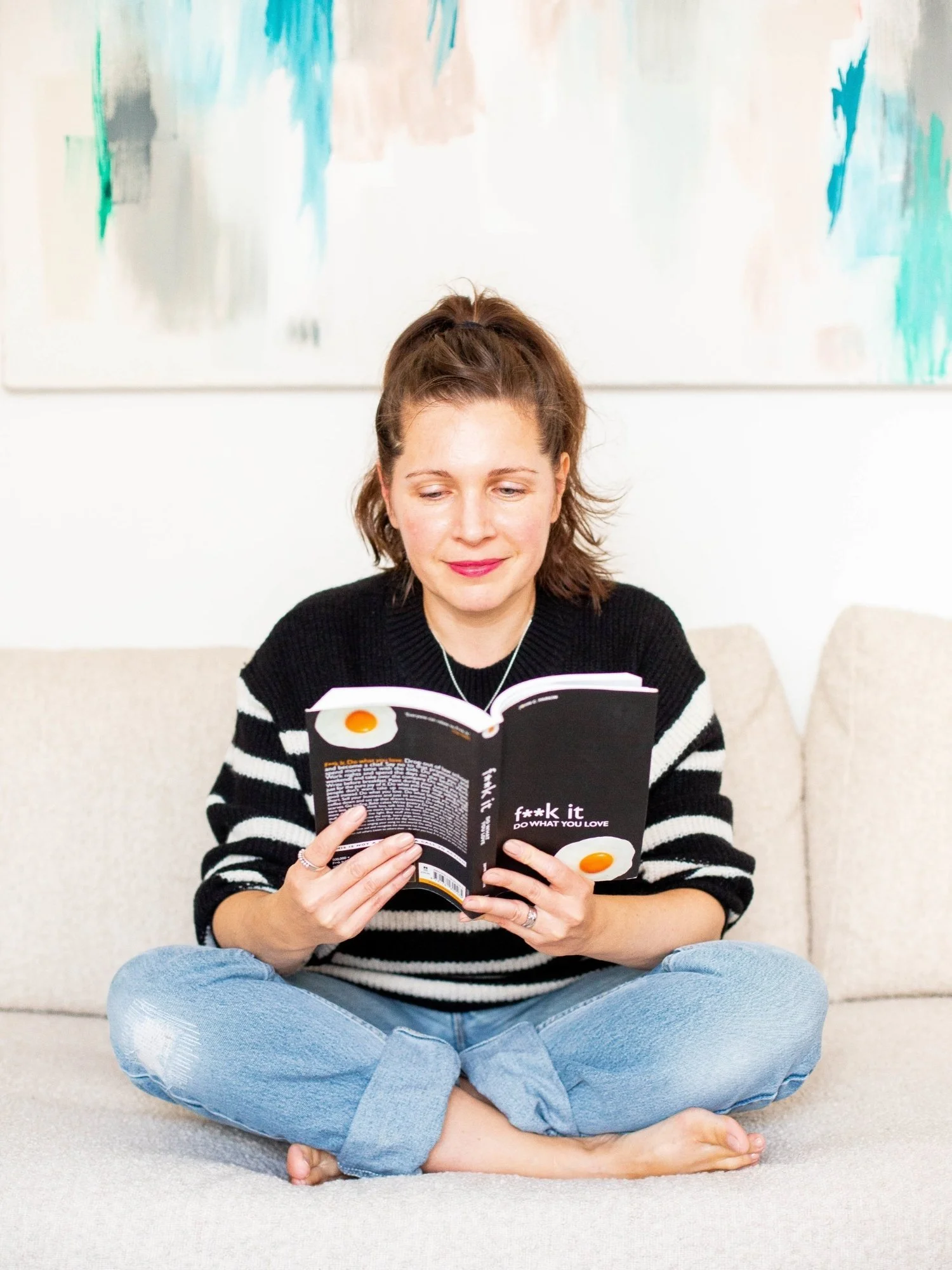 Sam Ferguson, sitting cross legged and reading a book