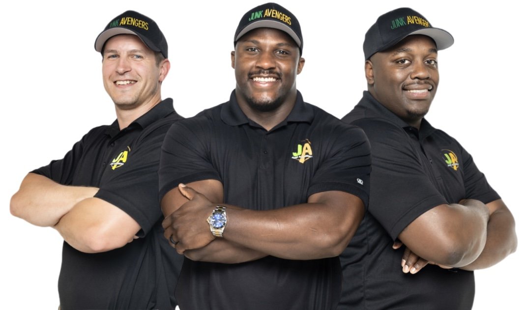 Three men in black polo shirts and caps with 'Junk Avengers' logo and text pose with arms crossed against a white background.