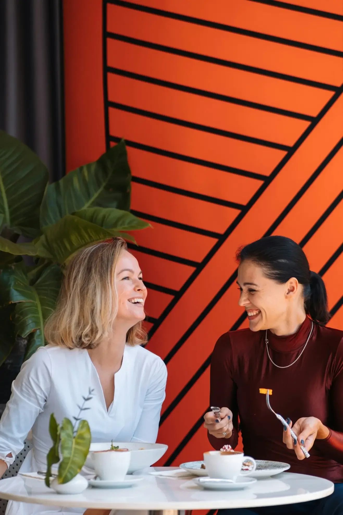 Two women enjoying a meal together at a table, sharing food and conversation.