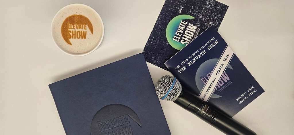 A cup of coffee with a logo reading 'Elevate Show' and a collection of tickets, a microphone, and a notebook for the Elevate Show event.