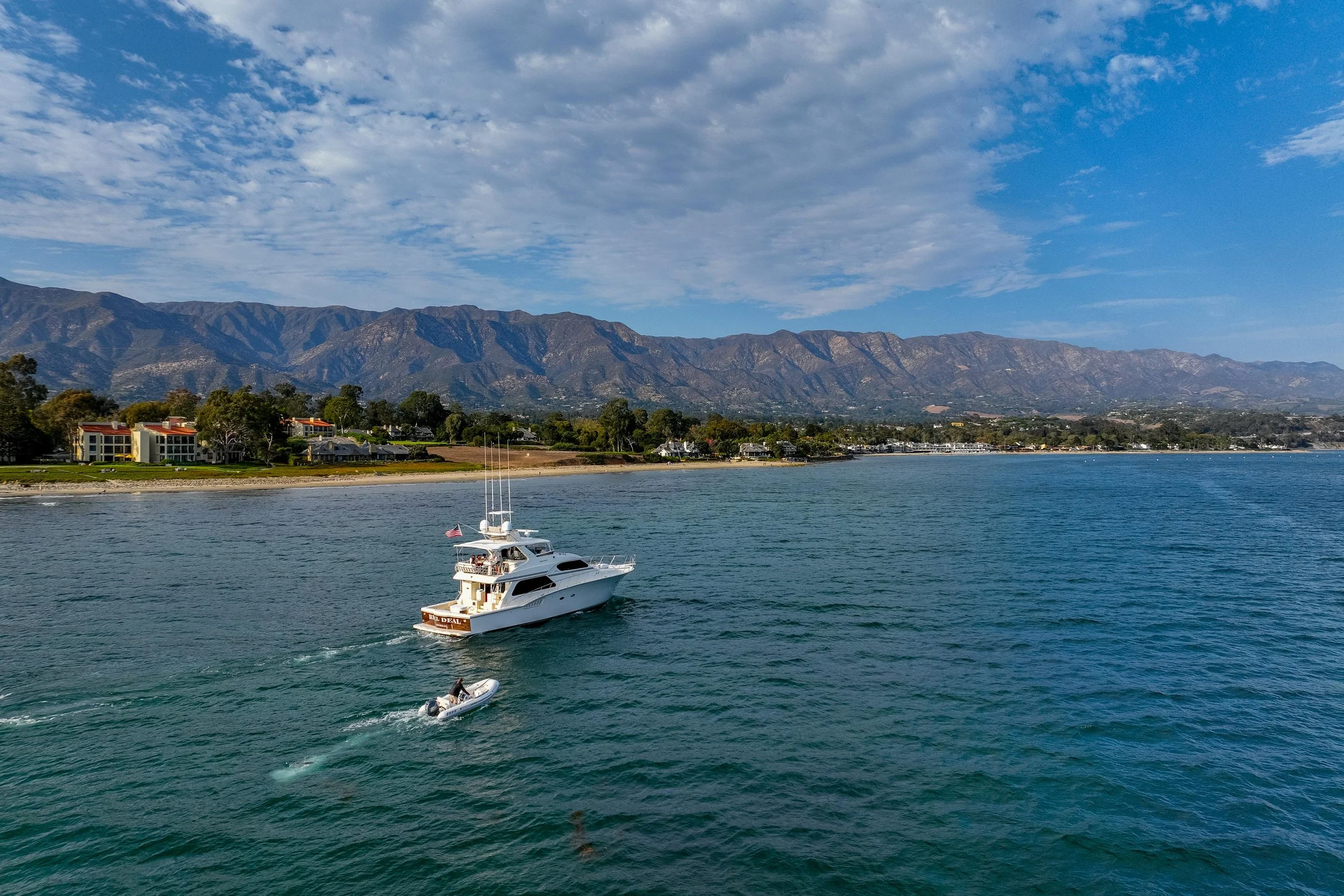 Aerial view of Mu Group private yacht as it cruises the beaches and coastline of Santa Barnara