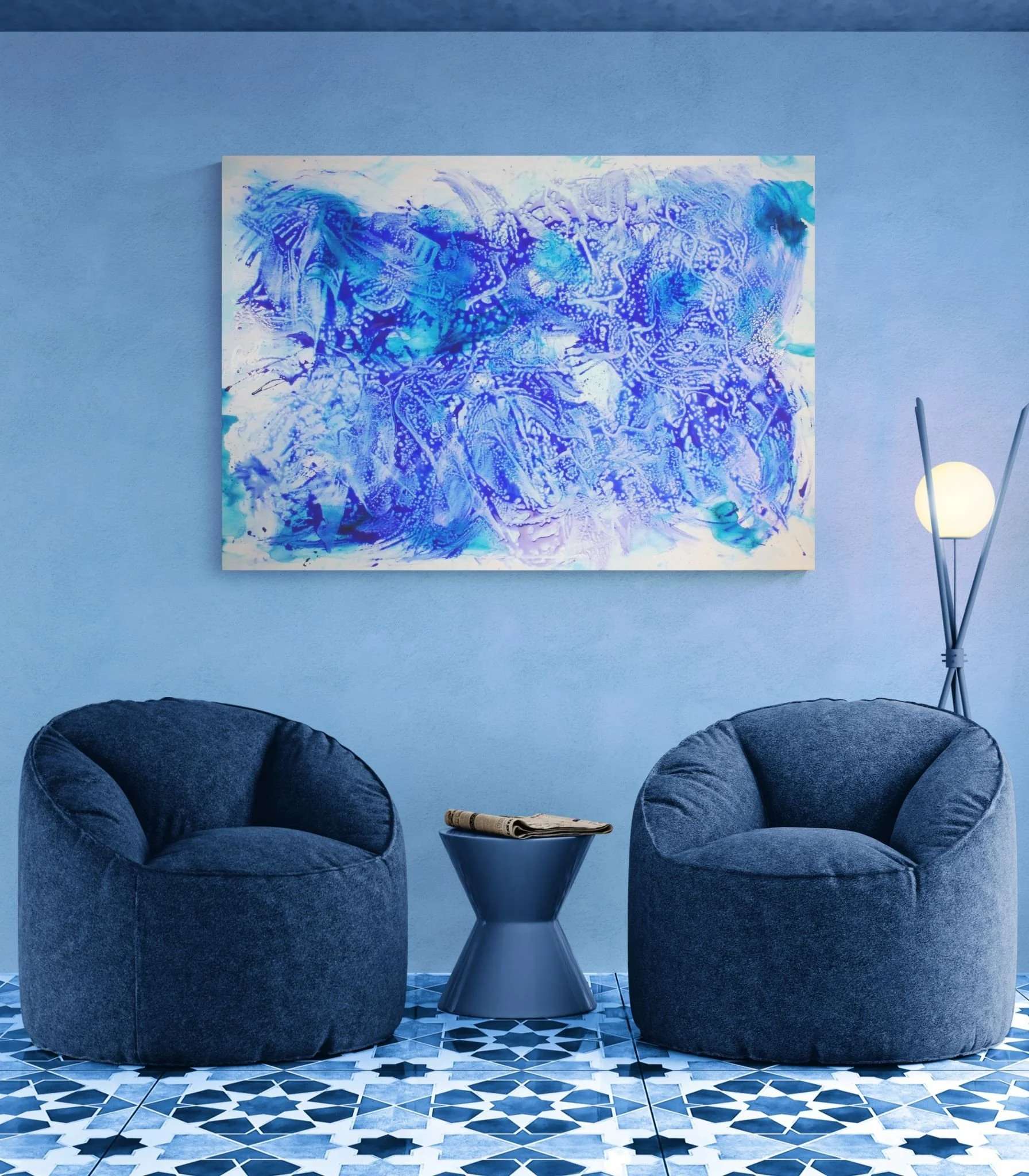 Blue living room with two velvet armchairs, a round side table with a rolled newspaper, and a modern floor lamp, with a large abstract blue and white painting hanging on the wall