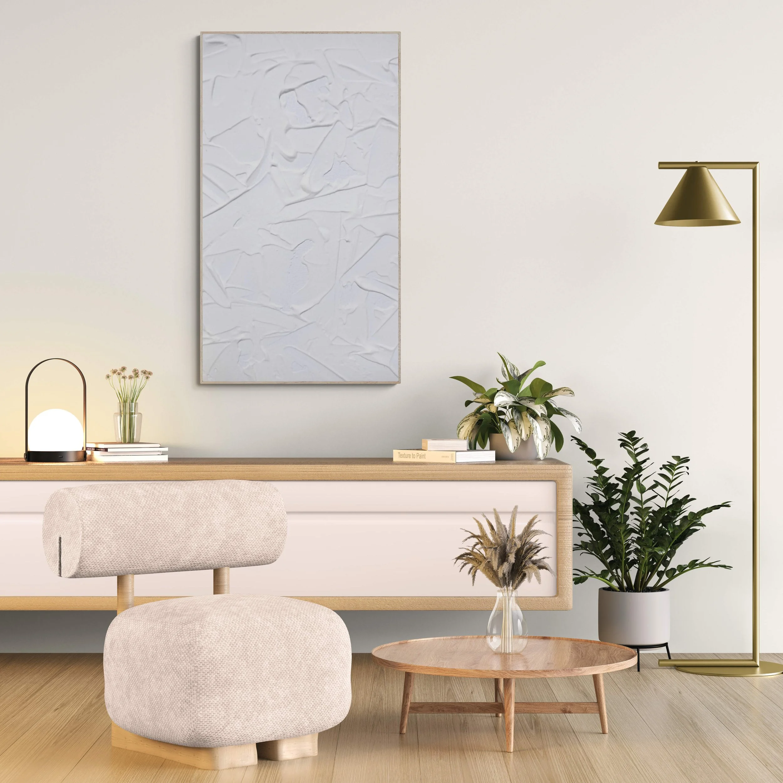 A living room corner with a wall-mounted textured white art piece, a small table with plants and books, a beige upholstered chair, and a gold floor lamp.