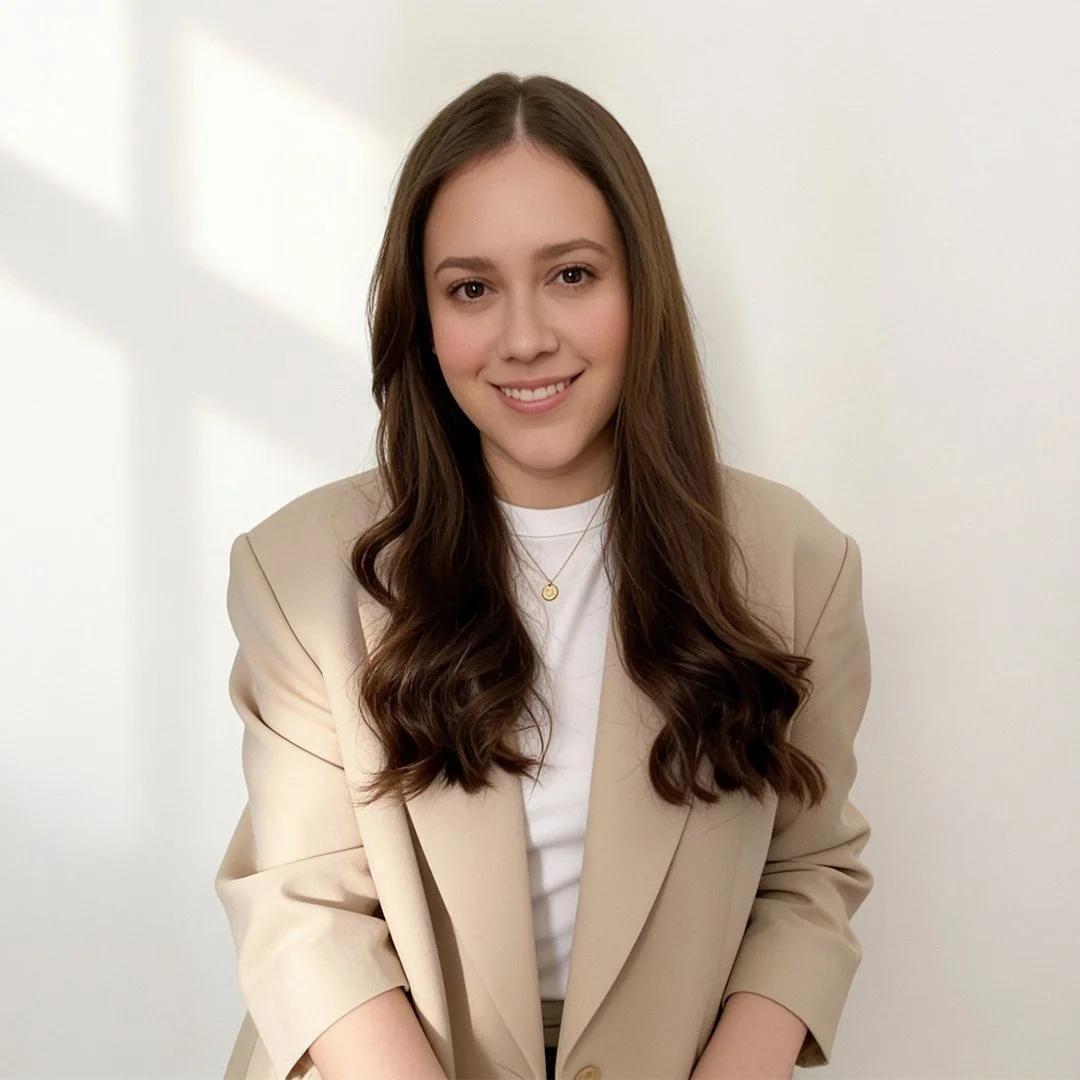 Portrait of a brand designer wearing a beige blazer against a soft neutral background.