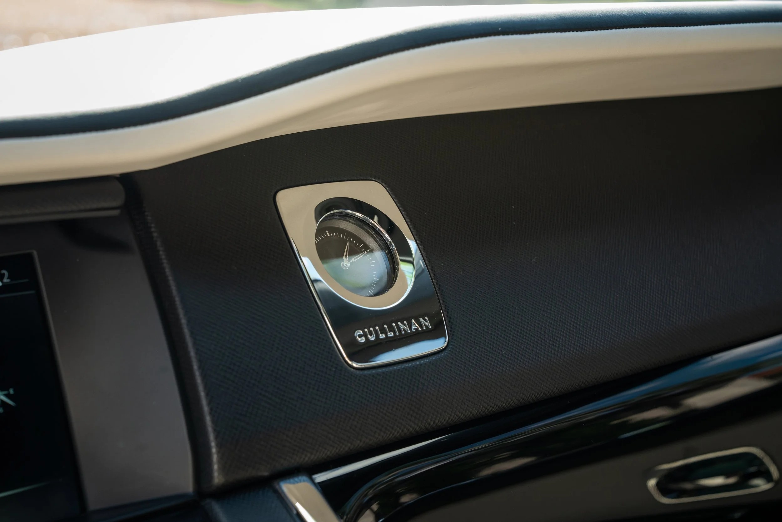 Close-up of a car's dashboard with a clock with the brand name 'GULLINAN' on it.