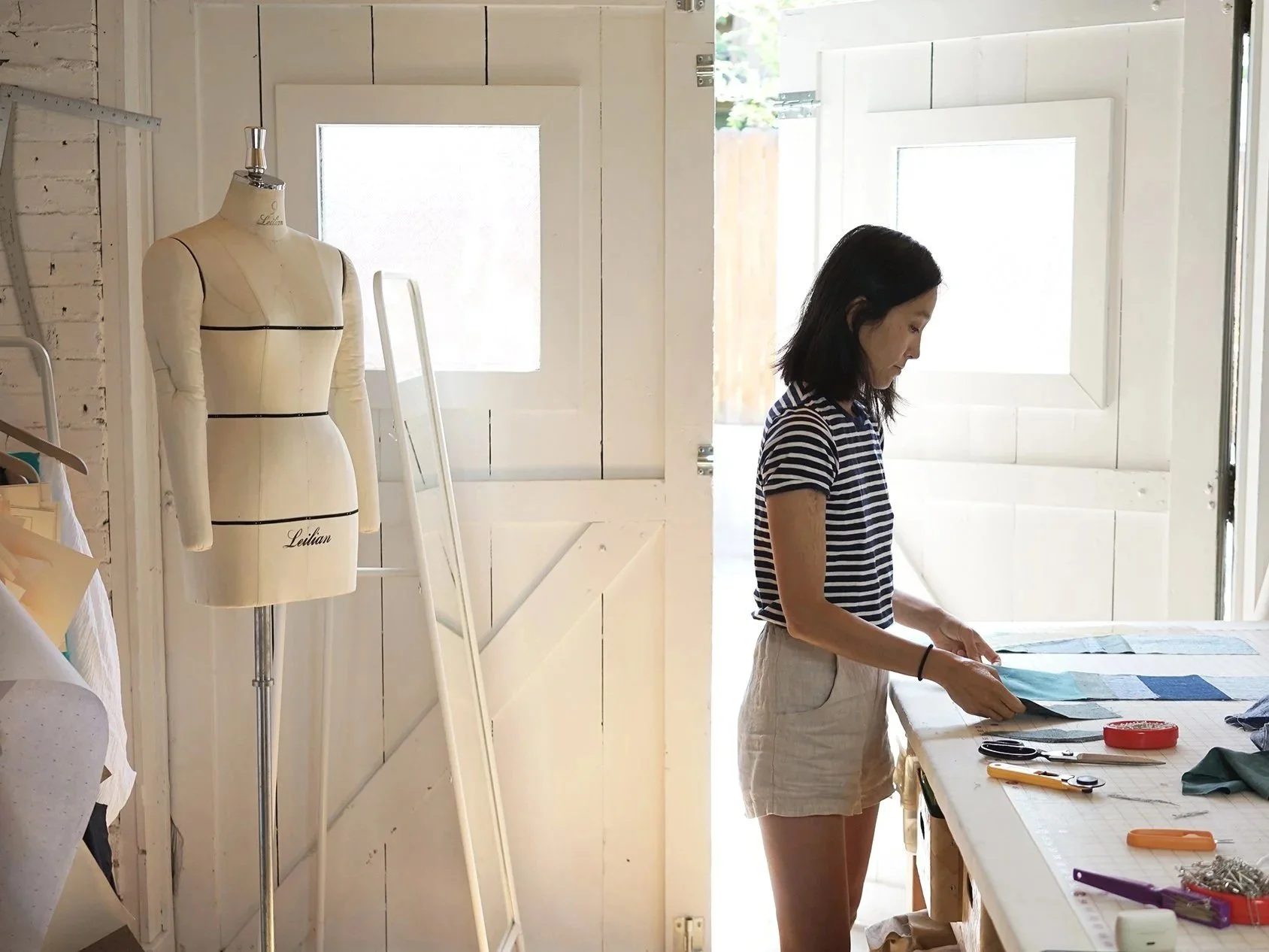 Mimi Shim, Denver sewing pattern designer, cutting jogakbo patchwork fabric in her sewing studio — creator of beginner-friendly PDF sewing patterns and video tutorials.