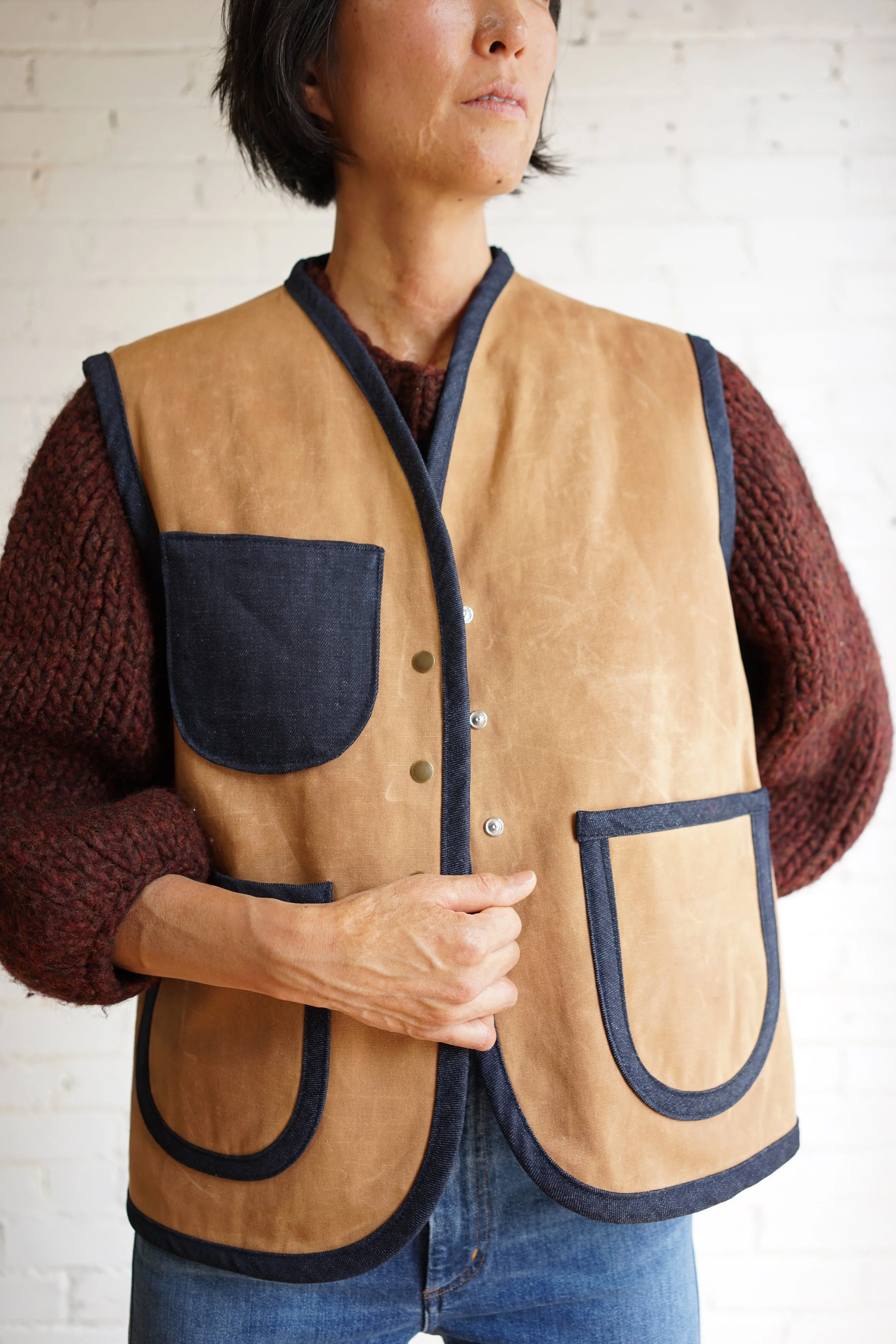 Nomad vest sewing pattern — waxed canvas vest with denim bias binding, patch pockets, and snap closures, designed by Mimi Shim Studio