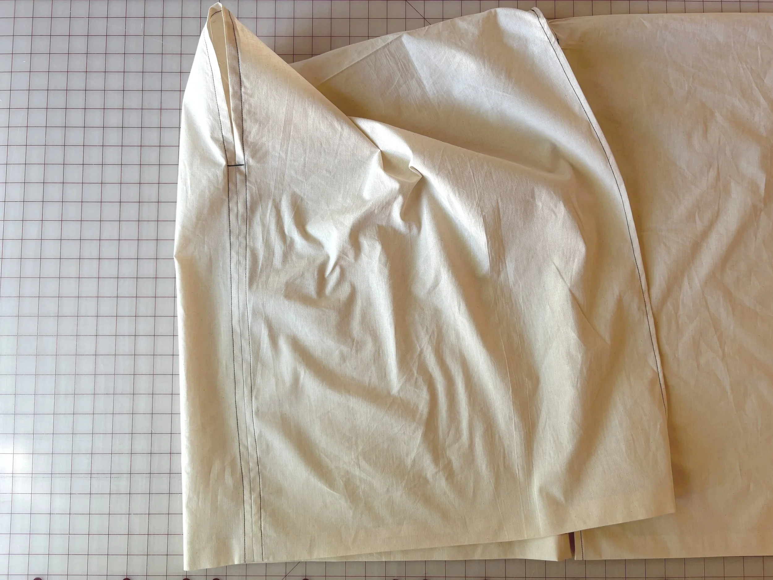 Finished armhole and side seam from above, showing the folded, topstitched edge