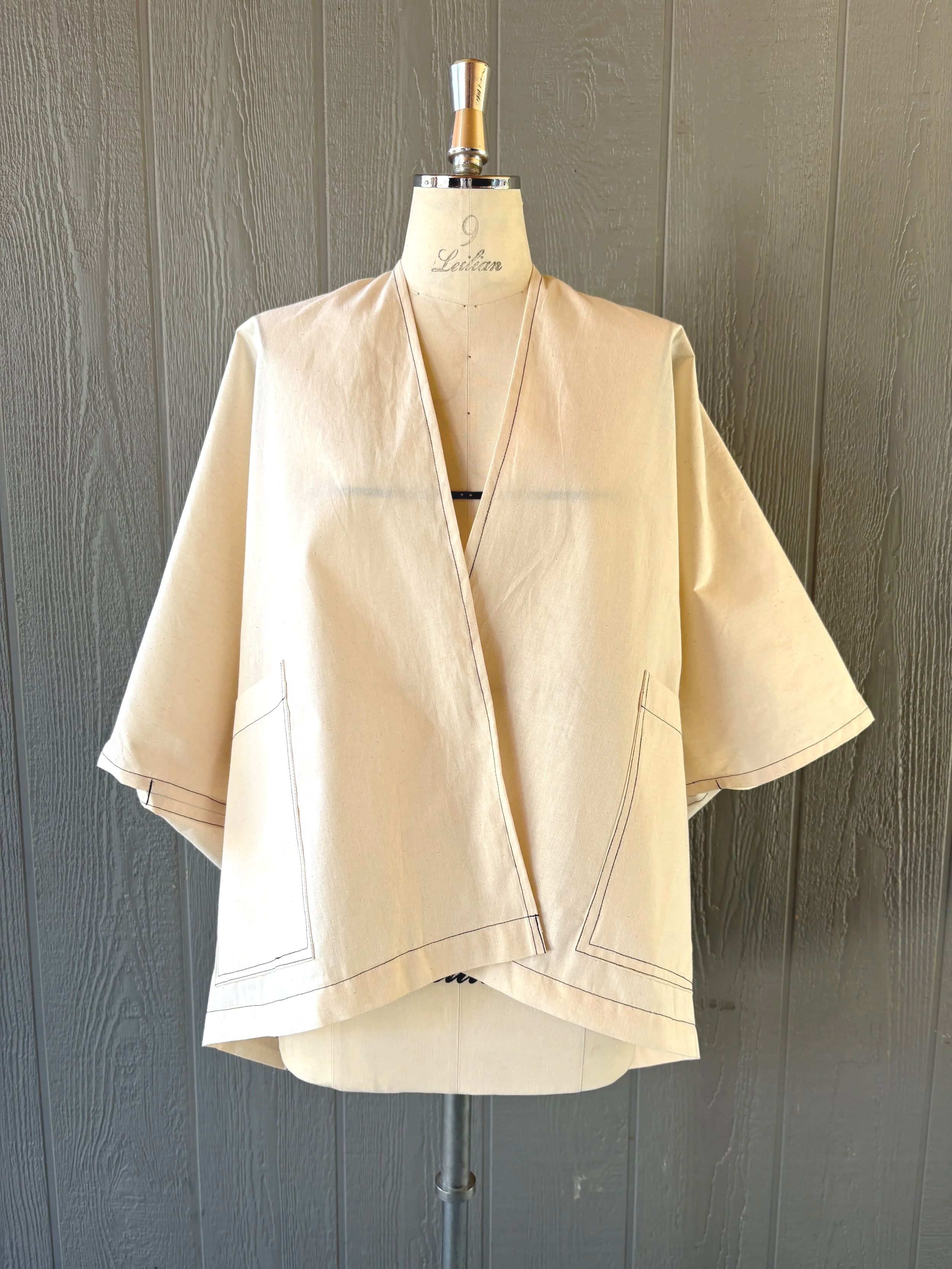 Finished kimono wrap cover-up in muslin, front view, showing the center front opening and drape