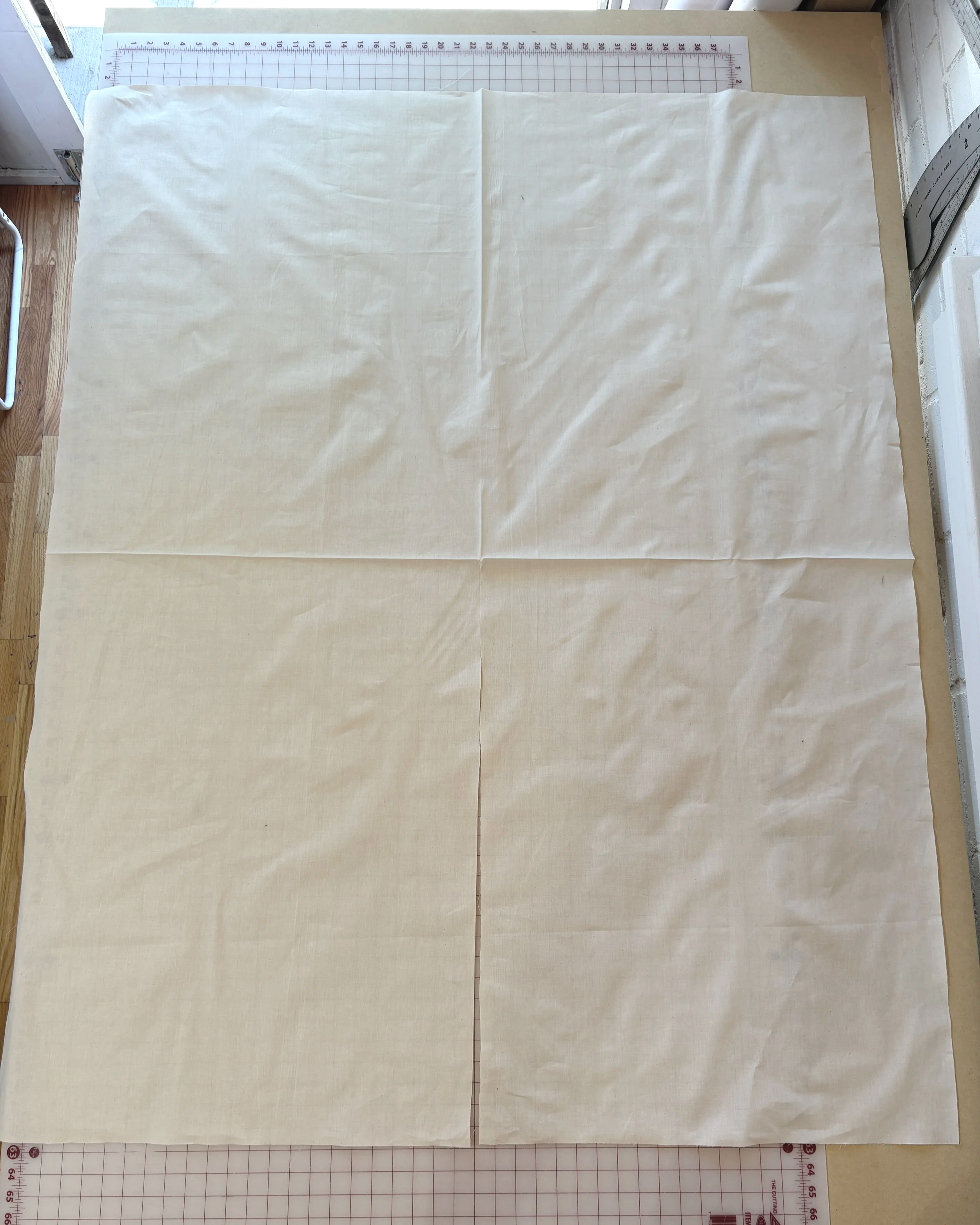 Wrap rectangle laid flat with lengthwise and widthwise creases pressed in, marking the center point for the kimono opening