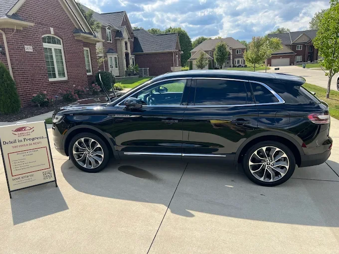 Steam cleaning car seats during mobile interior detailing in Clinton Township, Michigan.