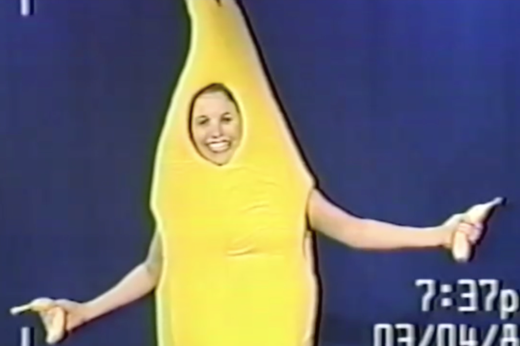 Mary in a banana suit costume and holding bananas smiling at the camera