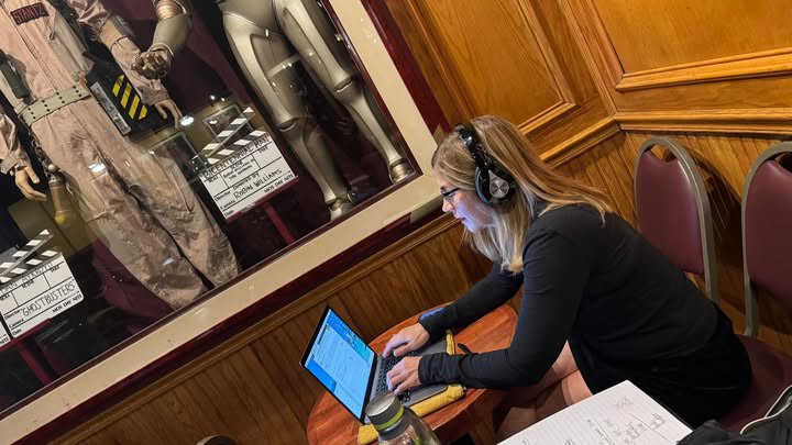 Mary Gallagher working on a laptop in the showroom at The Comedy and Magic Club