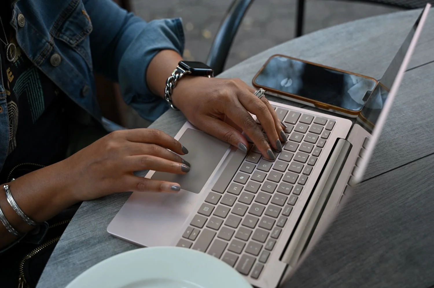 Hands typing on a laptop while working on copy for a private practice therapist website