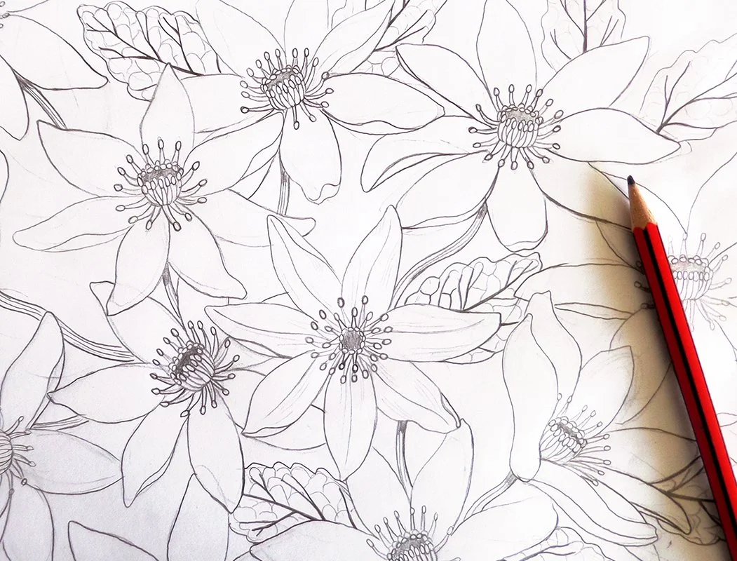 Line drawing of a floral pattern with multiple large flowers and leaves, with a red pencil on the paper.