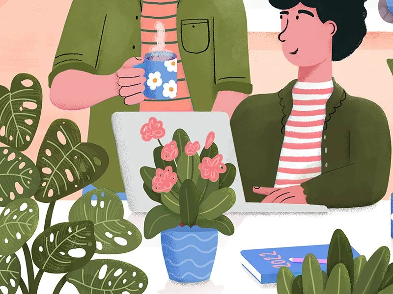 Two people in casual clothing smiling at a laptop with a pink flower arrangement on the desk, a person holding a steaming mug decorated with white flowers, surrounded by houseplants.