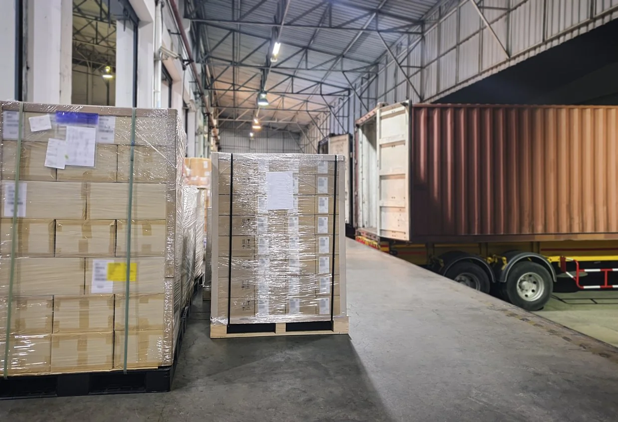 Fragile pallets being loaded for delivery in a warehouse loading bay